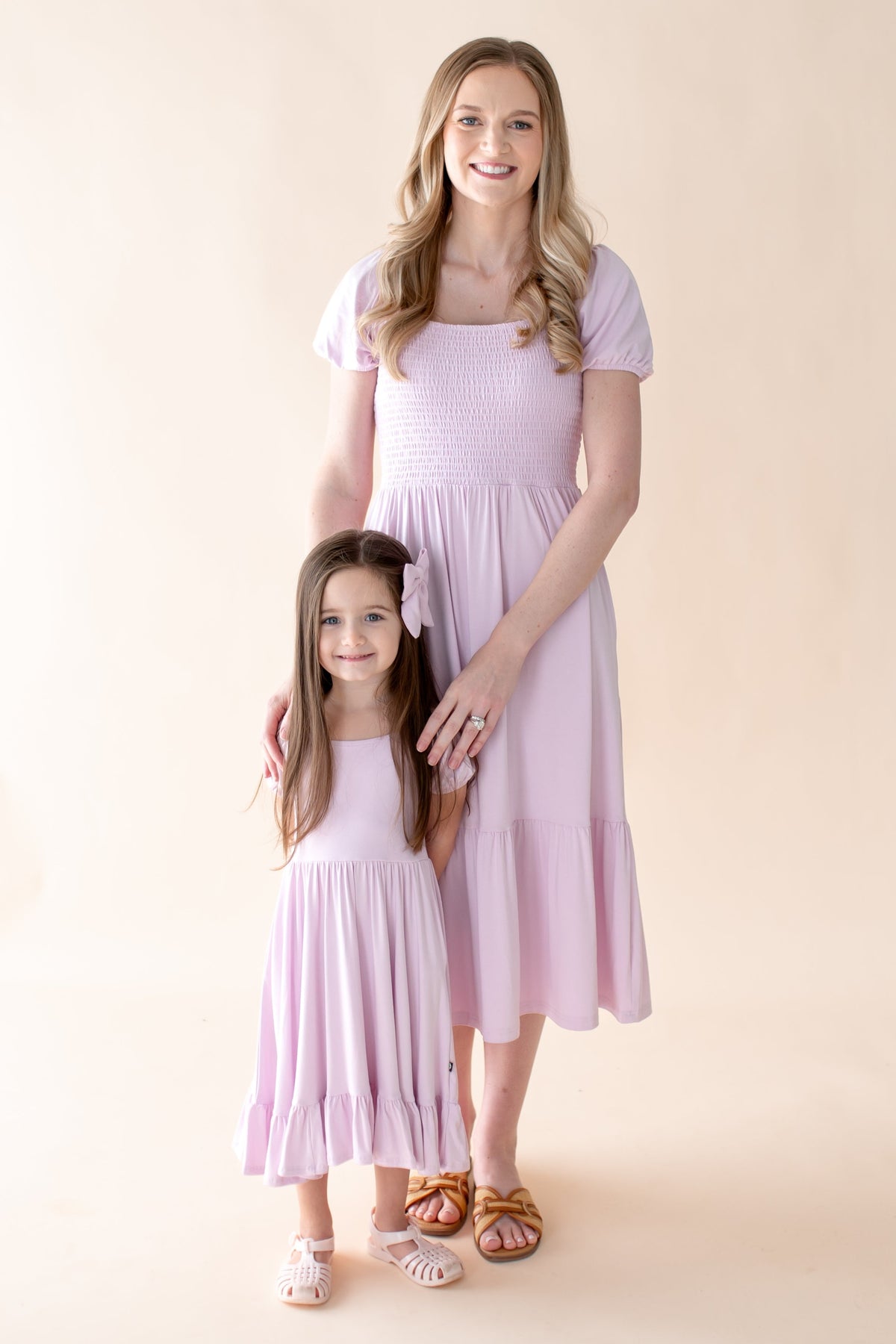 Woman and young child wearing mommy and me matching light purple spring midi dresses