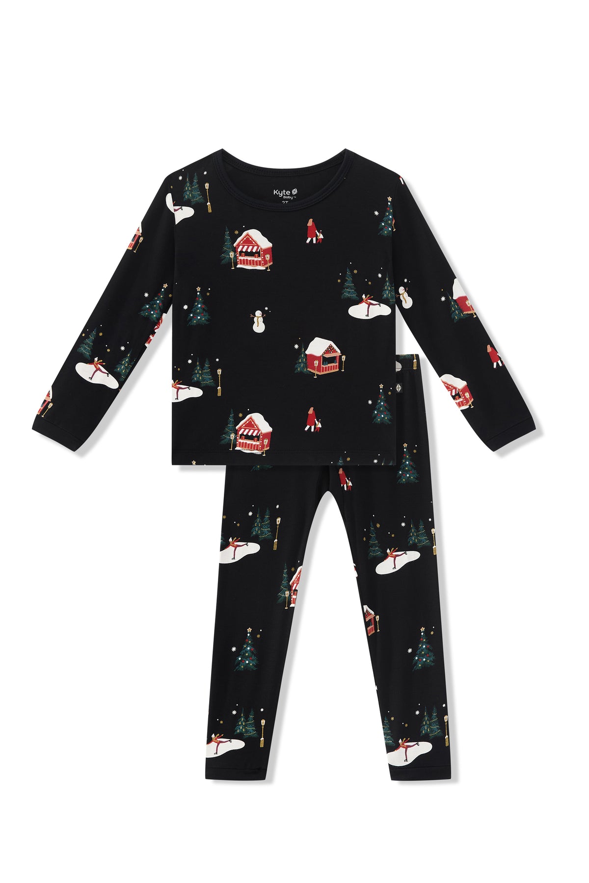 A two-piece children's pajama set featuring a long-sleeve top and matching pants in black with a festive winter holiday print of snow-covered cabins, Christmas trees, and snowmen.