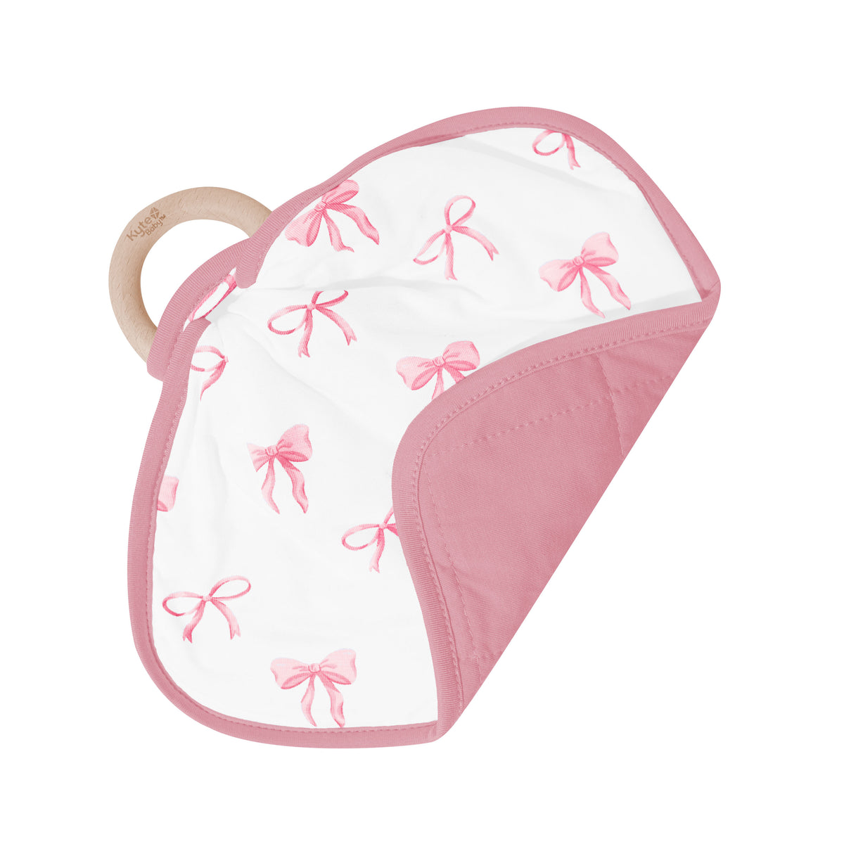 The Lovey in Bow with Removable Wooden Teething Ring shown on its wooden ring with the corner folded over showing the dusty pink backing