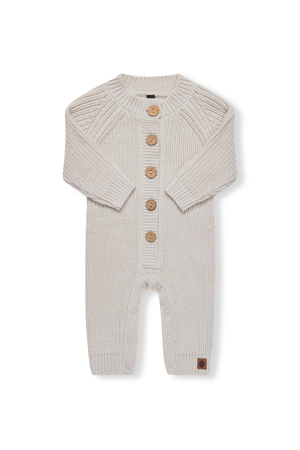Chunky Knit Jumpsuit in oat with folded sleeves on a white background