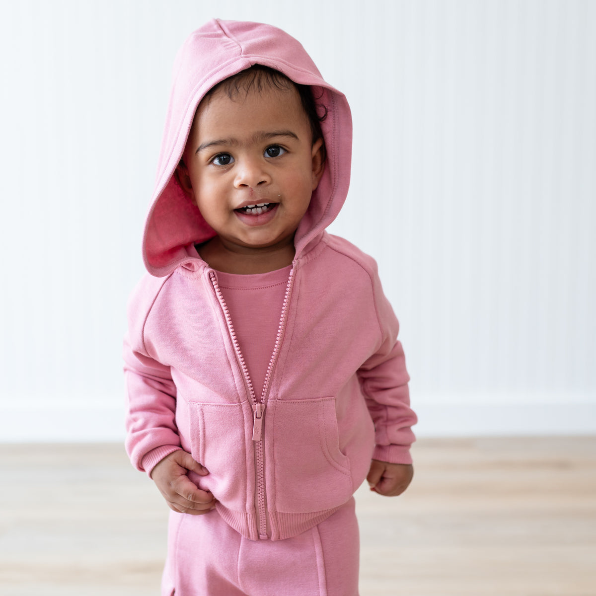 Close up of a young toddler wearing the Fleece Zip Up Hoodie in Apple Blossom