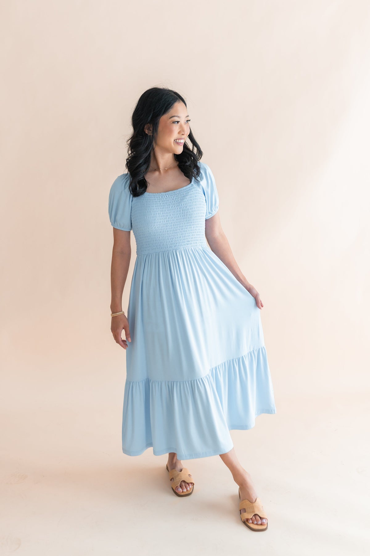 Female modeling the Women’s Smocked Dress in Breeze in front of a light neutral background