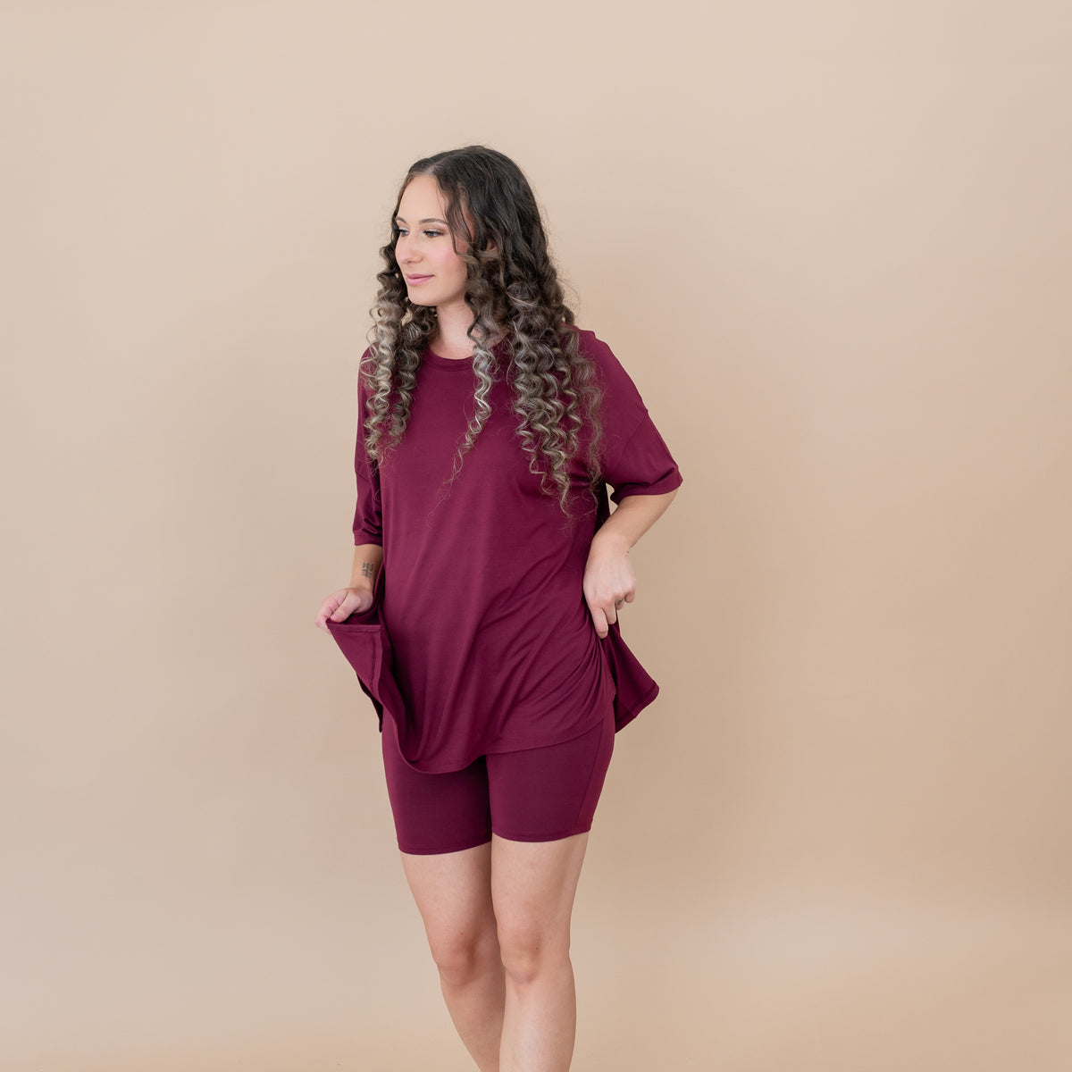 Female model standing looking off to the side wearing the Women’s Biker Short Set in Burgundy
