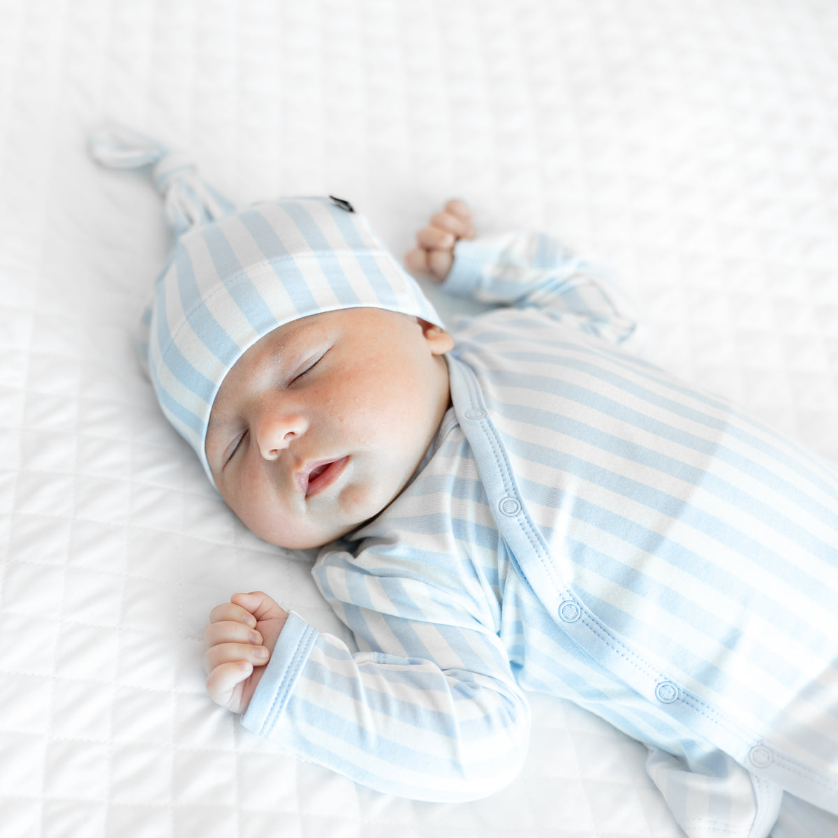 Close up of the baby's cap and top of the Take Me Home Set with Cap in Small Mist Stripe
