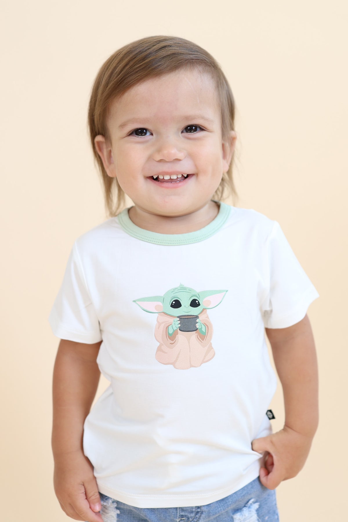 Young boy wearing the Toddler Basic Tee in The Child™ paired with light wash jeans