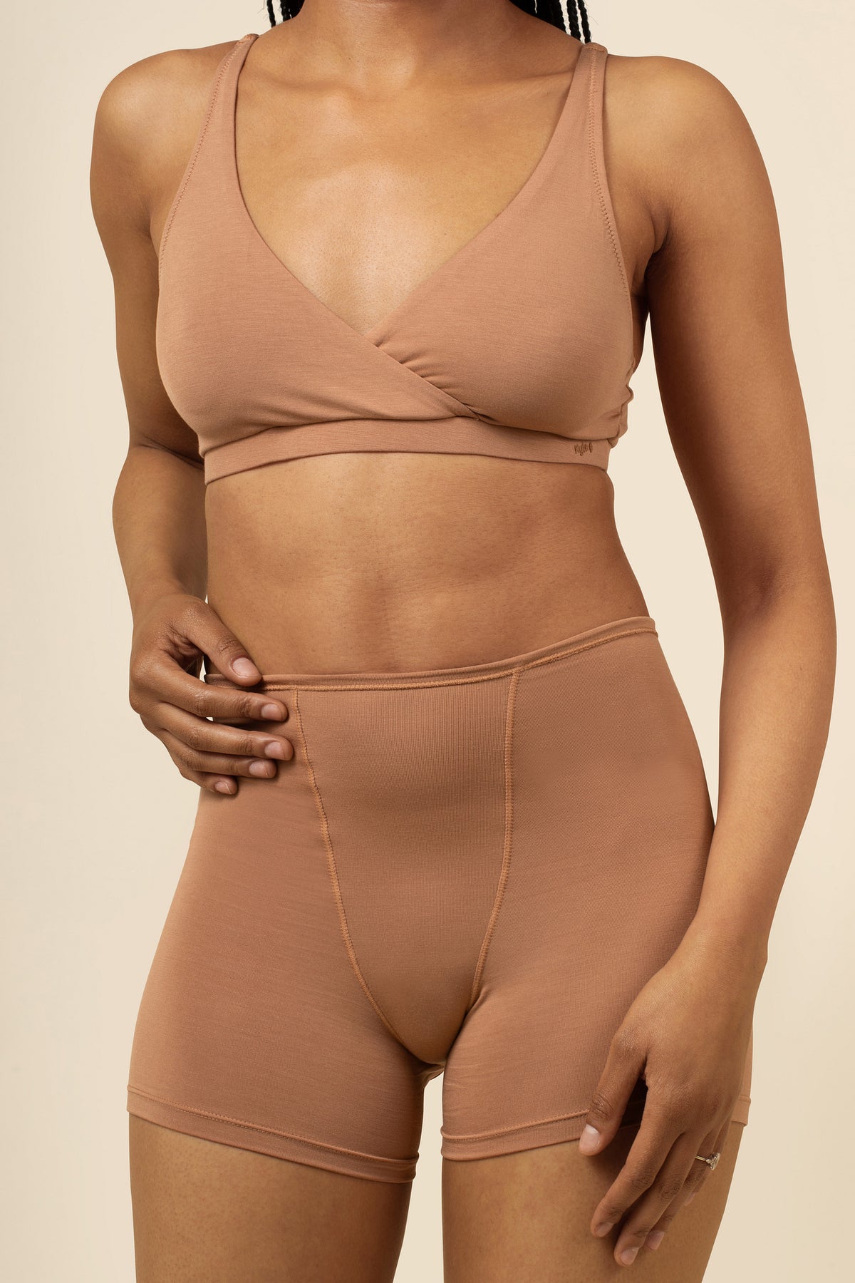 Woman wearing light brown bralette and boxer brief