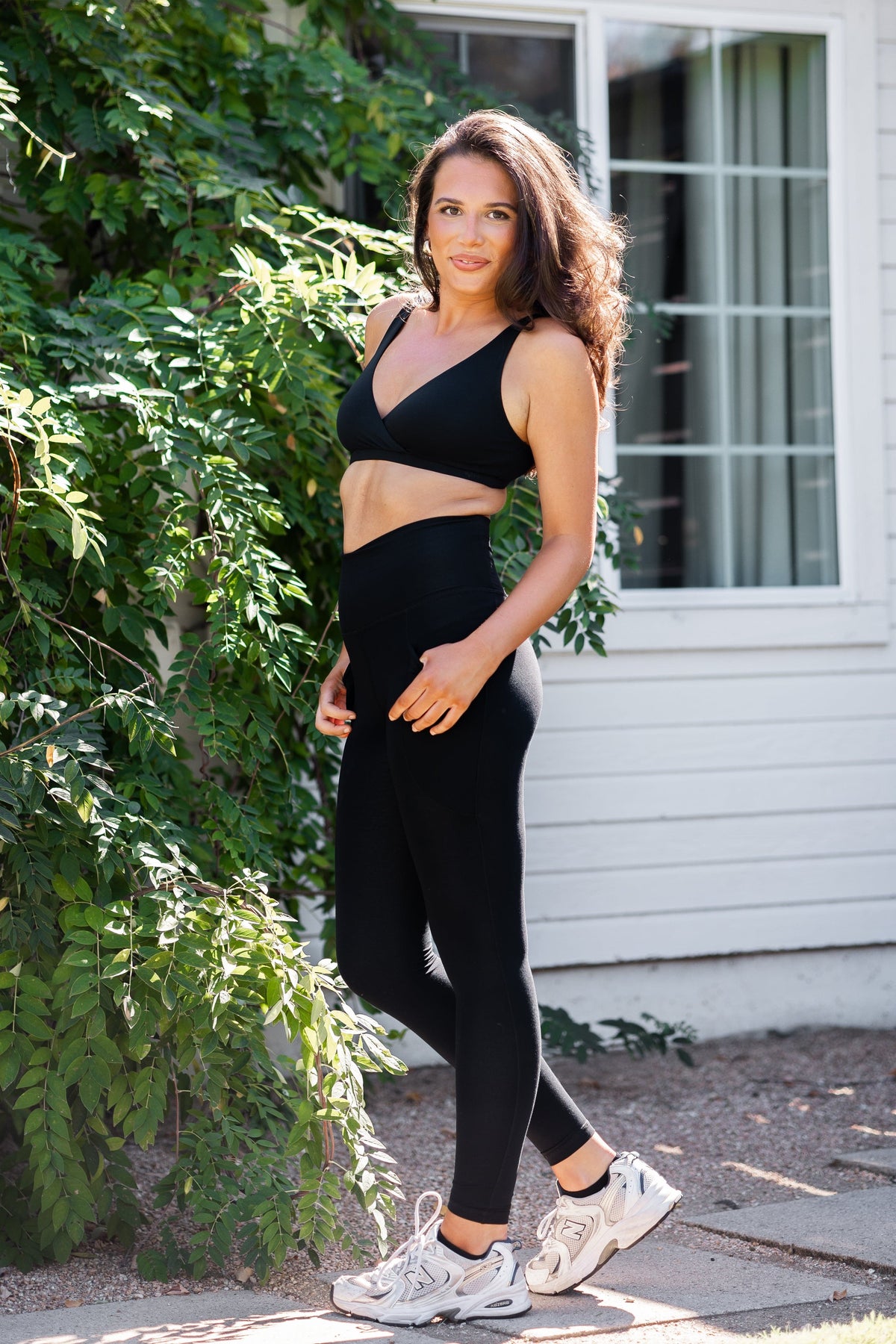 Female model posing wearing the Bamboo Flex Women’s Leggings in Midnight and matching cross front bralette