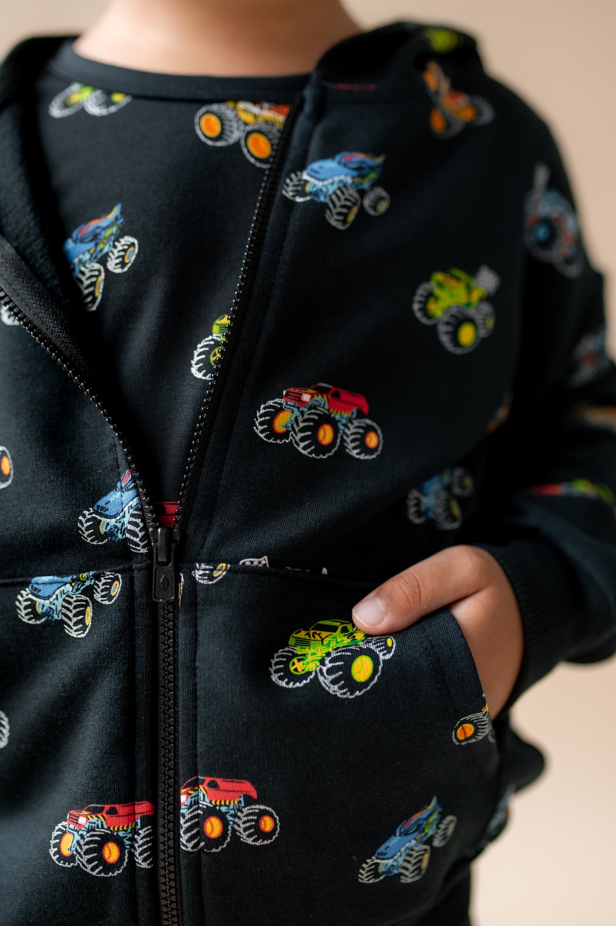 Close up of Black Zip-Up Hoodie in Monster Truck print with pockets