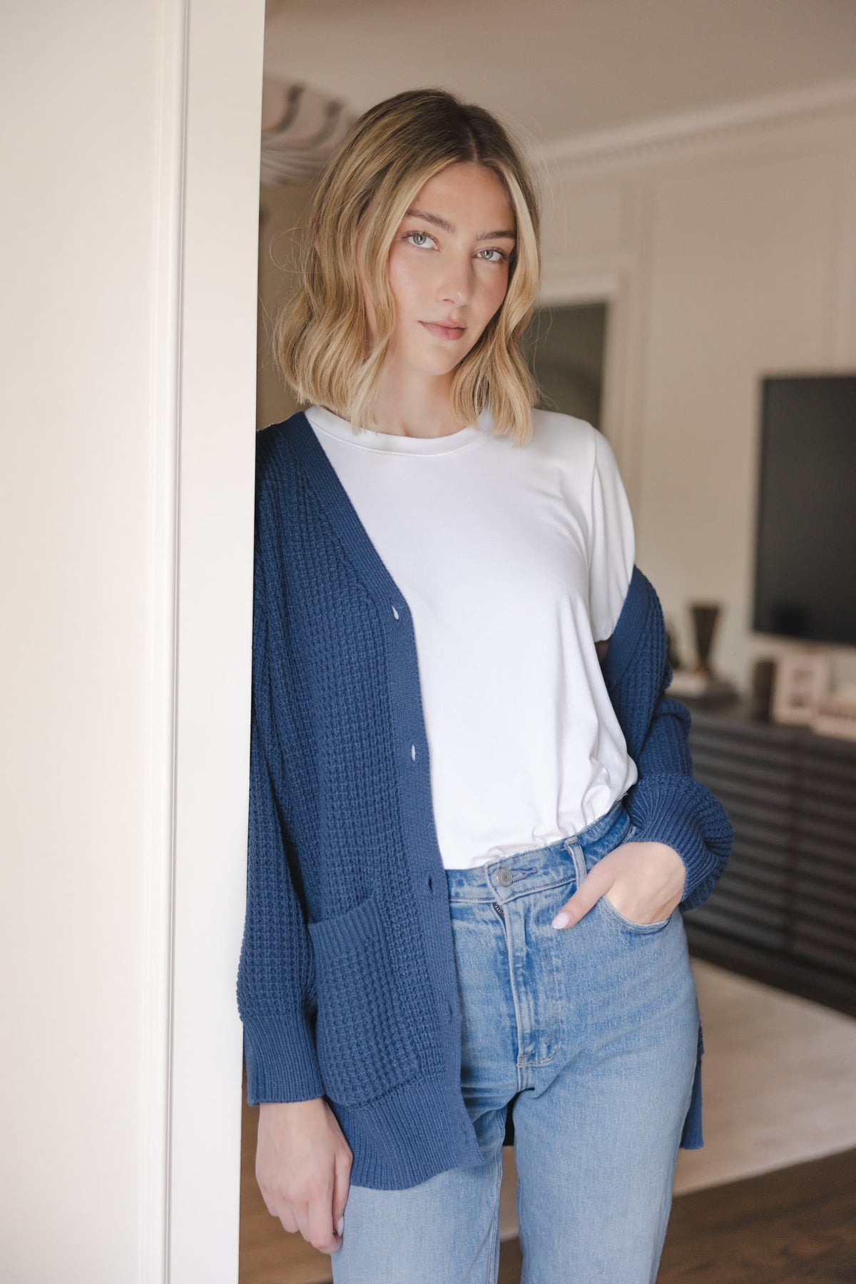 Modal posing in Chunky Knit Women's Waffle Cardigan in Oxford over white T-shirt and blue jeans
