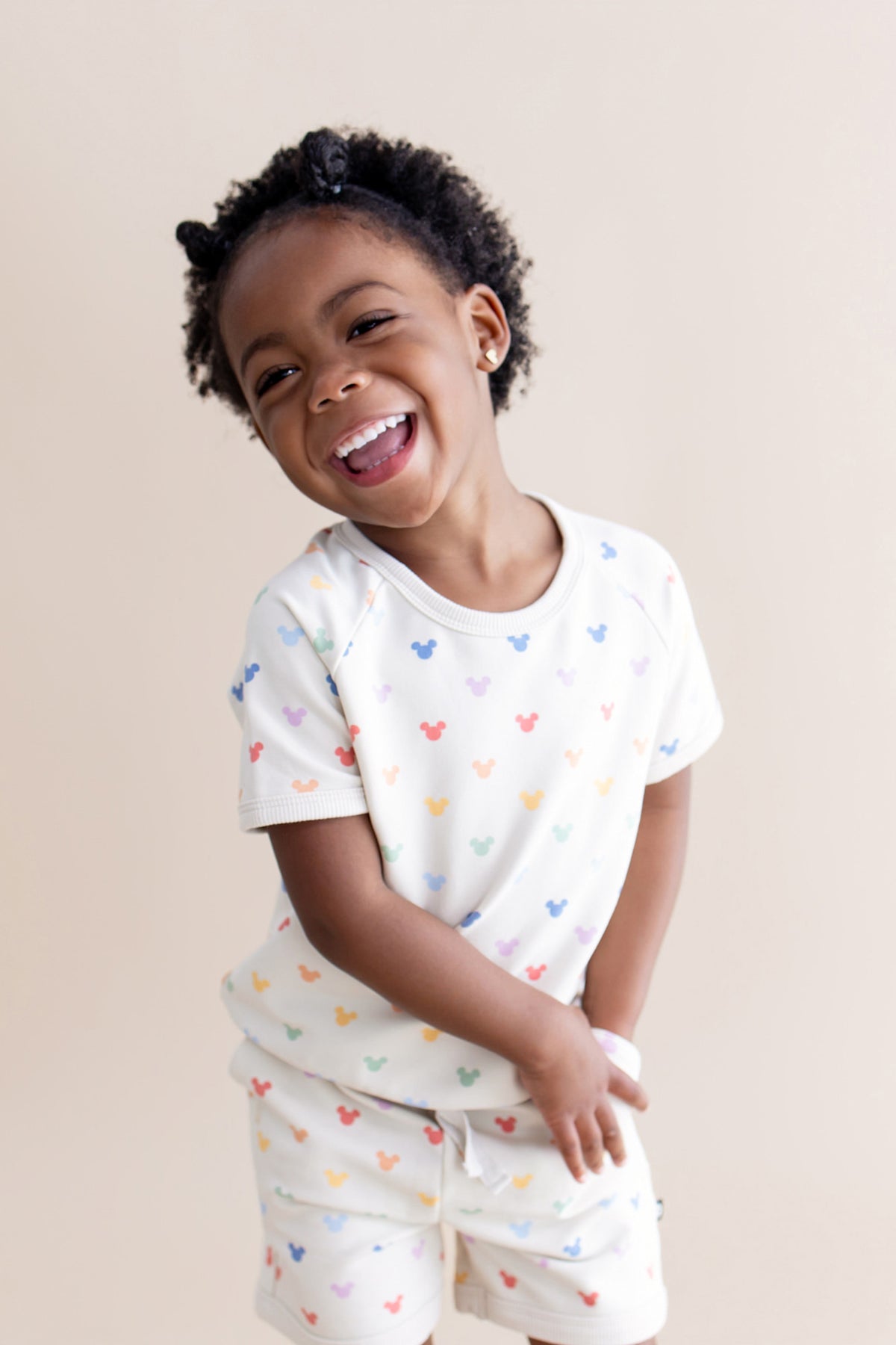 Girl smiling wearing pastel mickey head patterned matching set