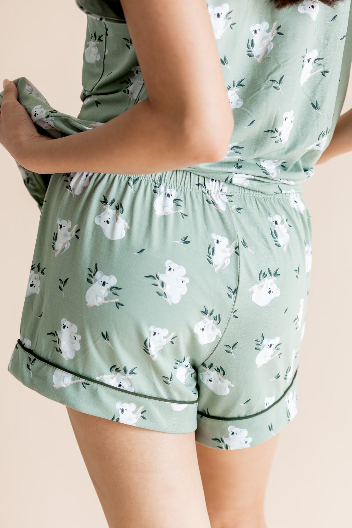 Model showing the back side of shorts of Women's Short Sleeve Pajama Set in Koala print on beige background