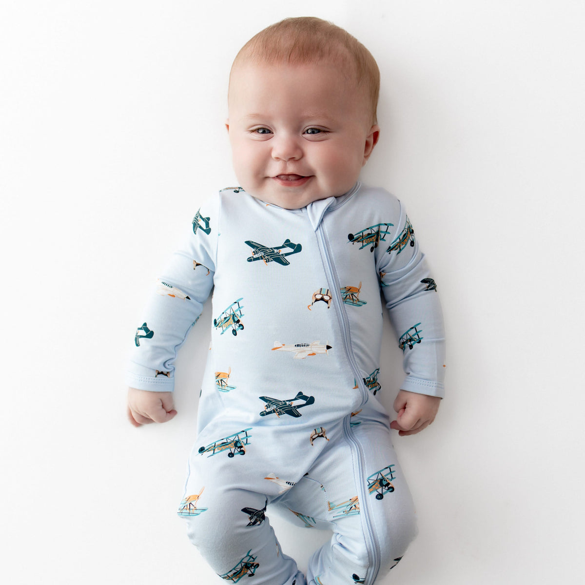 Close up of infant wearing the Zippered Romper in Take Off