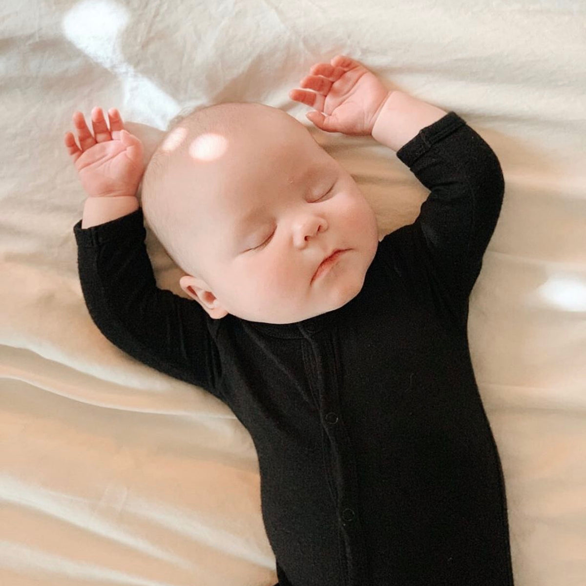 baby sleeping in midnight footie