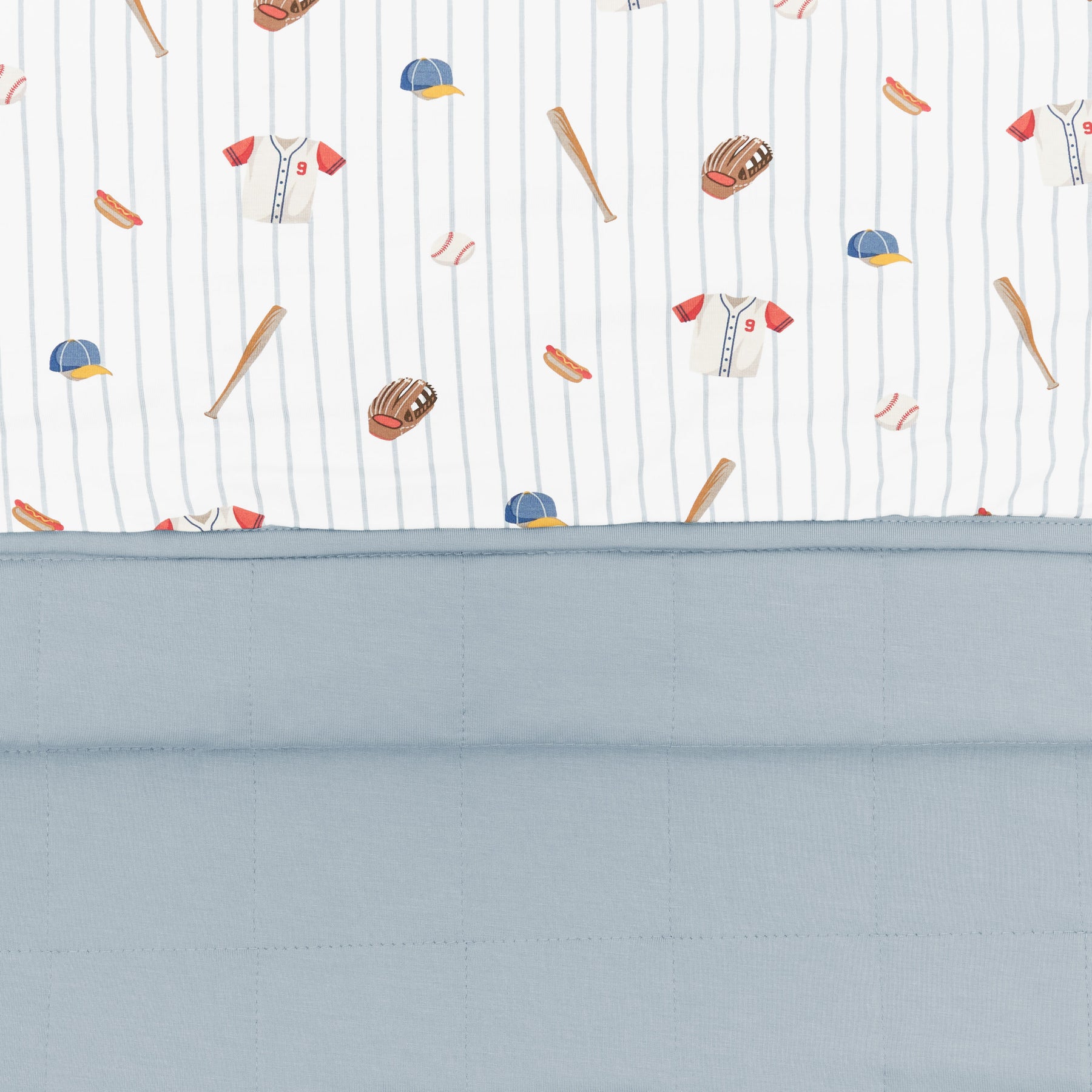 Close up of the Baby Blanket in Home Run showing the muted blue quilted backing and baseball print smooth top layer