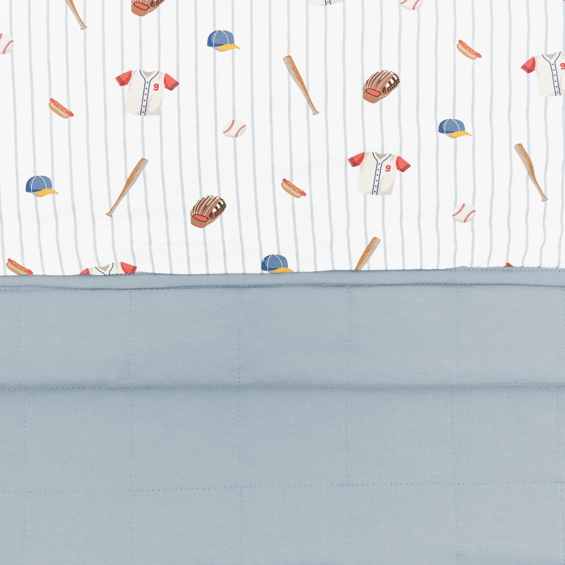 Close up of the Youth Blanket in Home Run 1.0 showing the muted blue quilted backing and smooth baseball print top layer