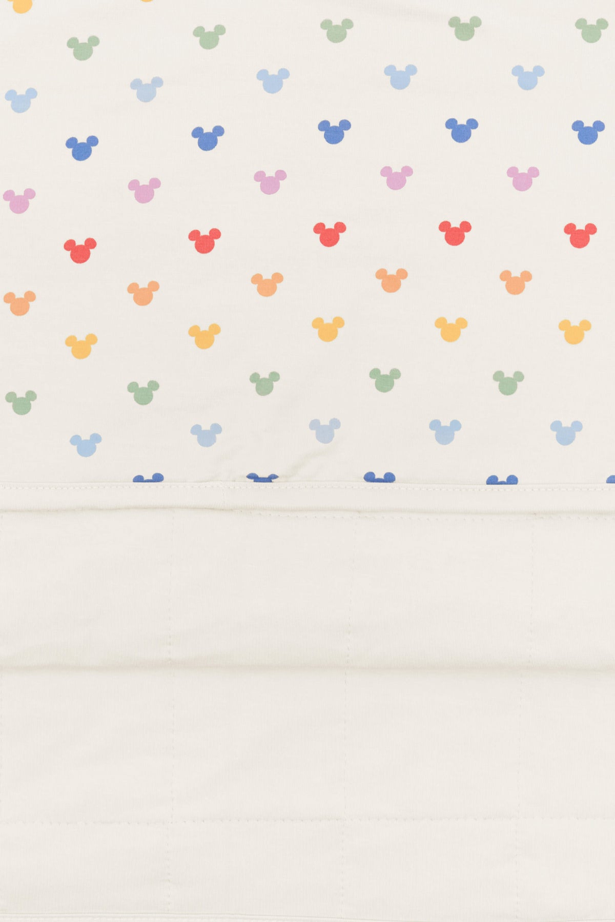 Back side fabric of baby blanket with pastel mickey mouse icons on an oat background