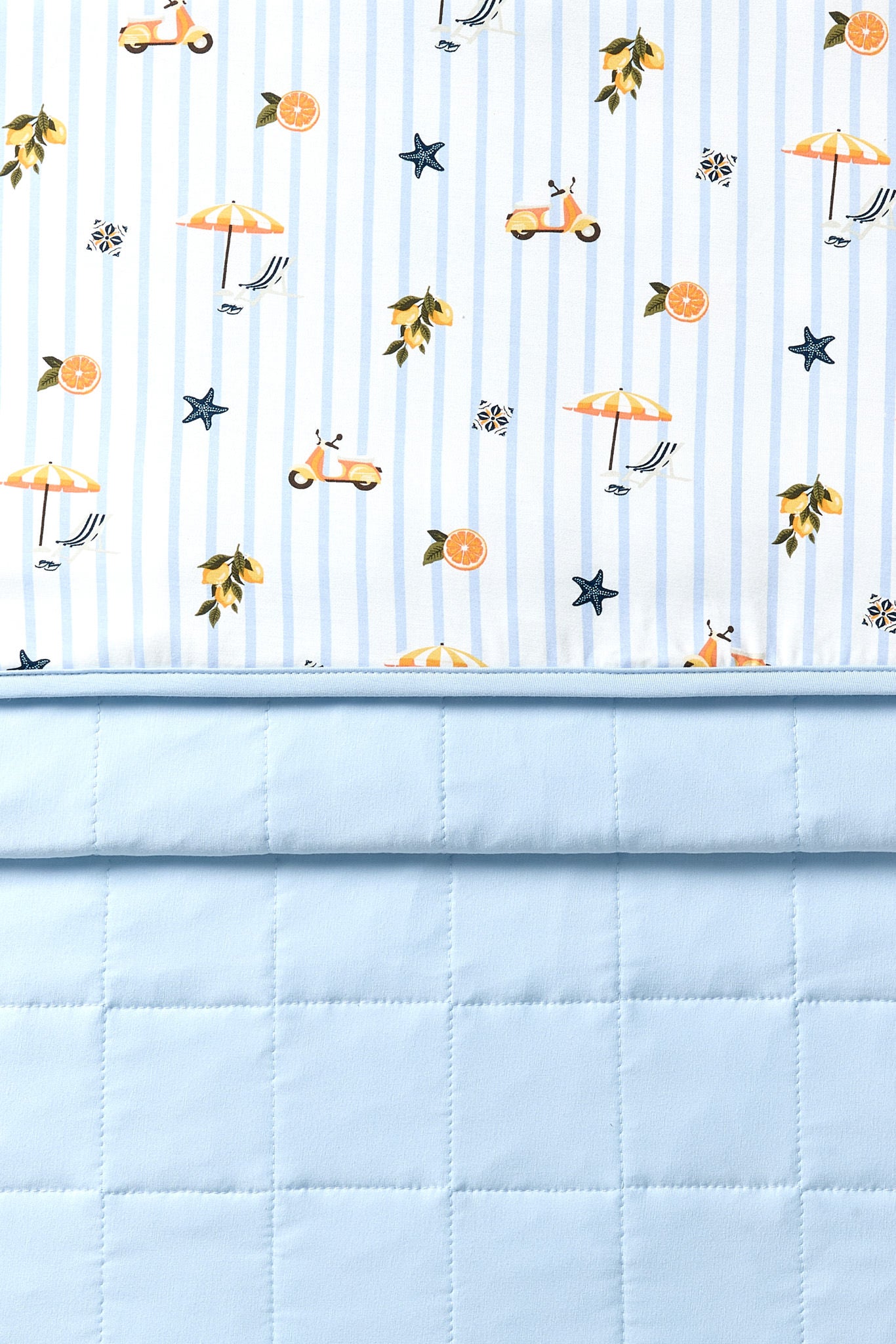 Close up of the Toddler Blanket in Amalfi Coast 1.0 showing the light blue quilted backing and smooth top printed layer