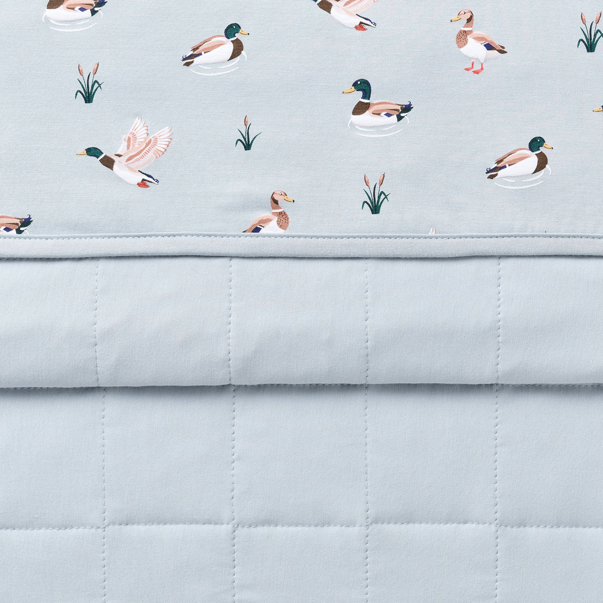 Close up of the Toddler Blanket in Mallard Duck 1.0 showing the light blue quilted backing and patterned smooth to player