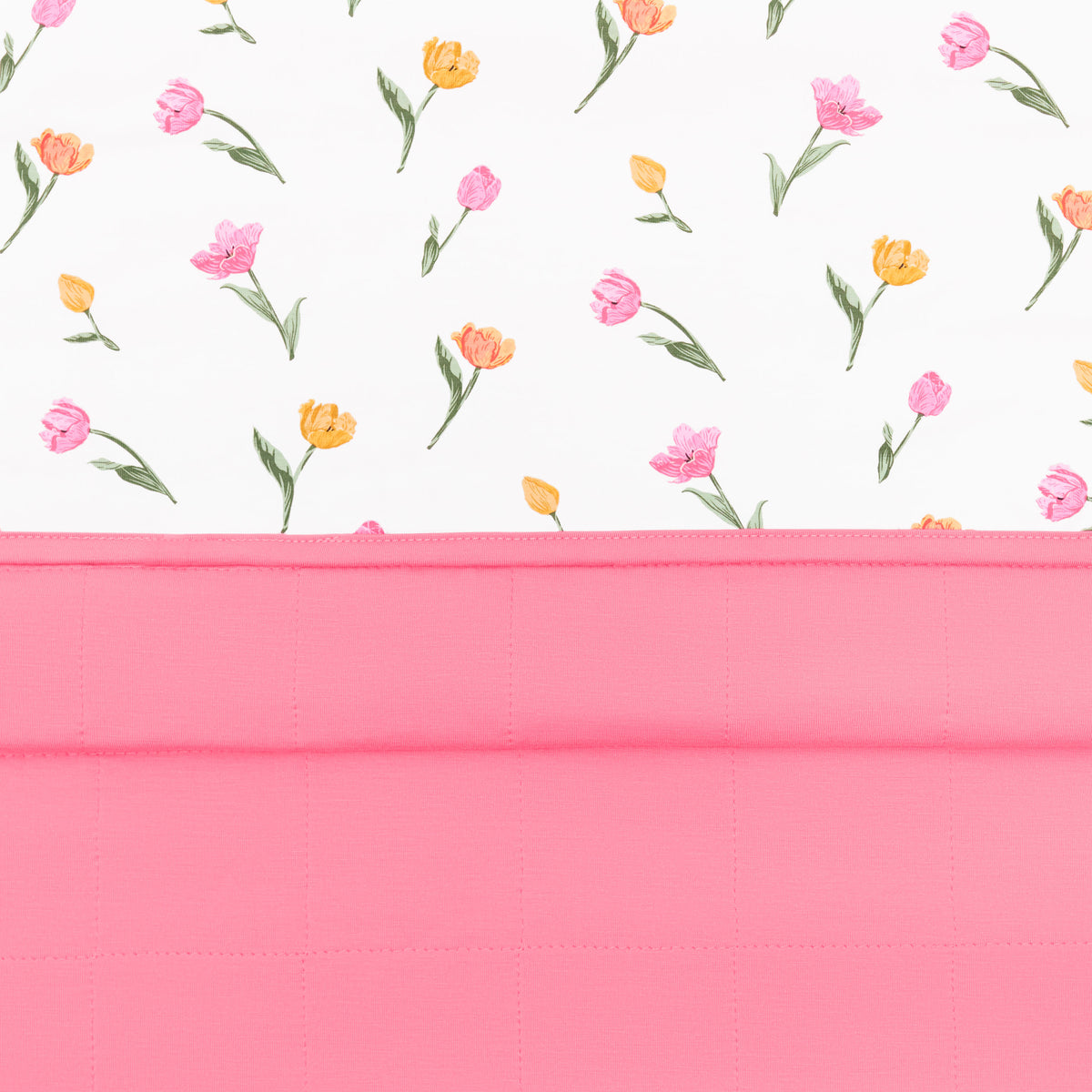 Close up of the Toddler Blanket in Tulip 1.0 showing the quilted pink backing and top floral smooth top layer
