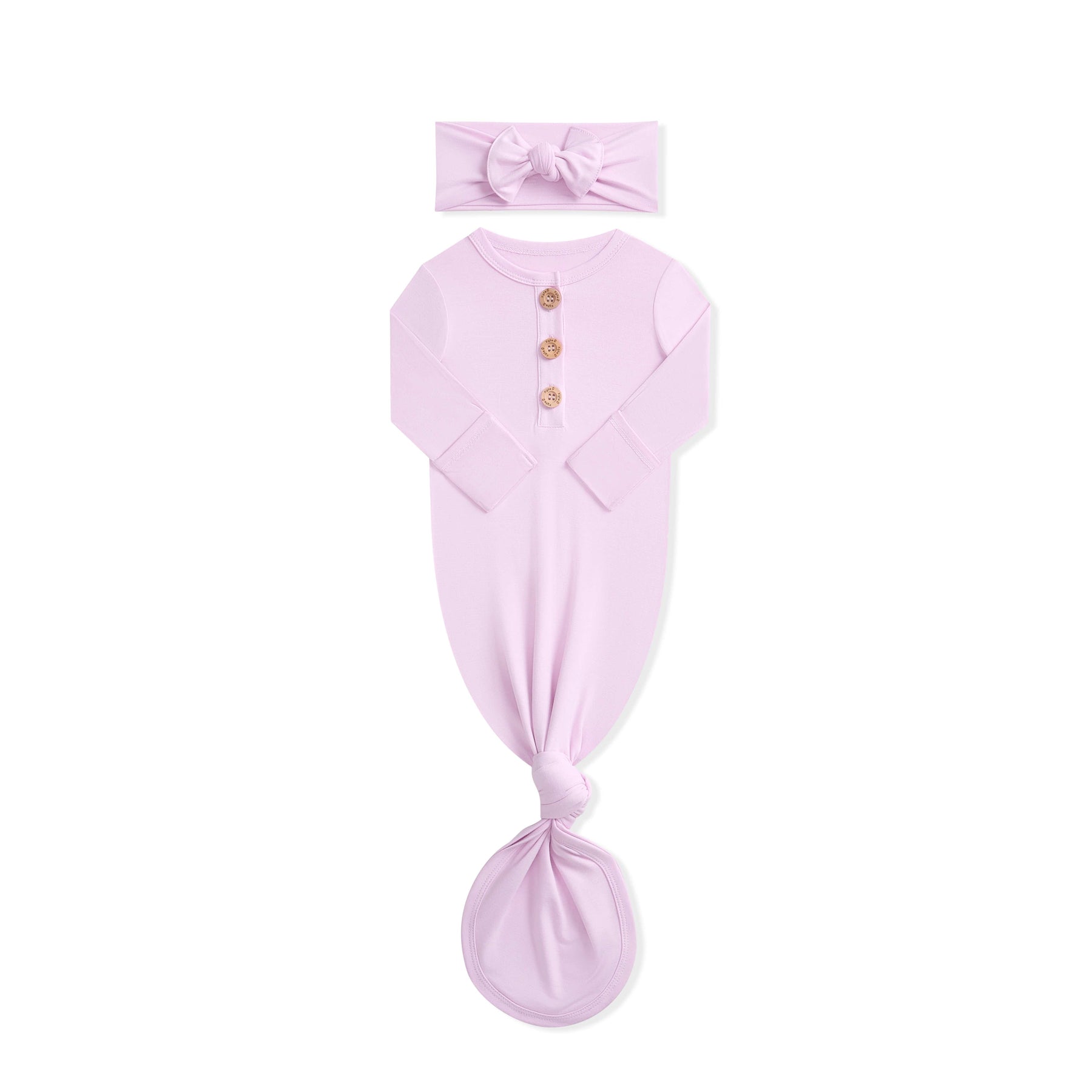 Pink baby gown and headband set on a white background