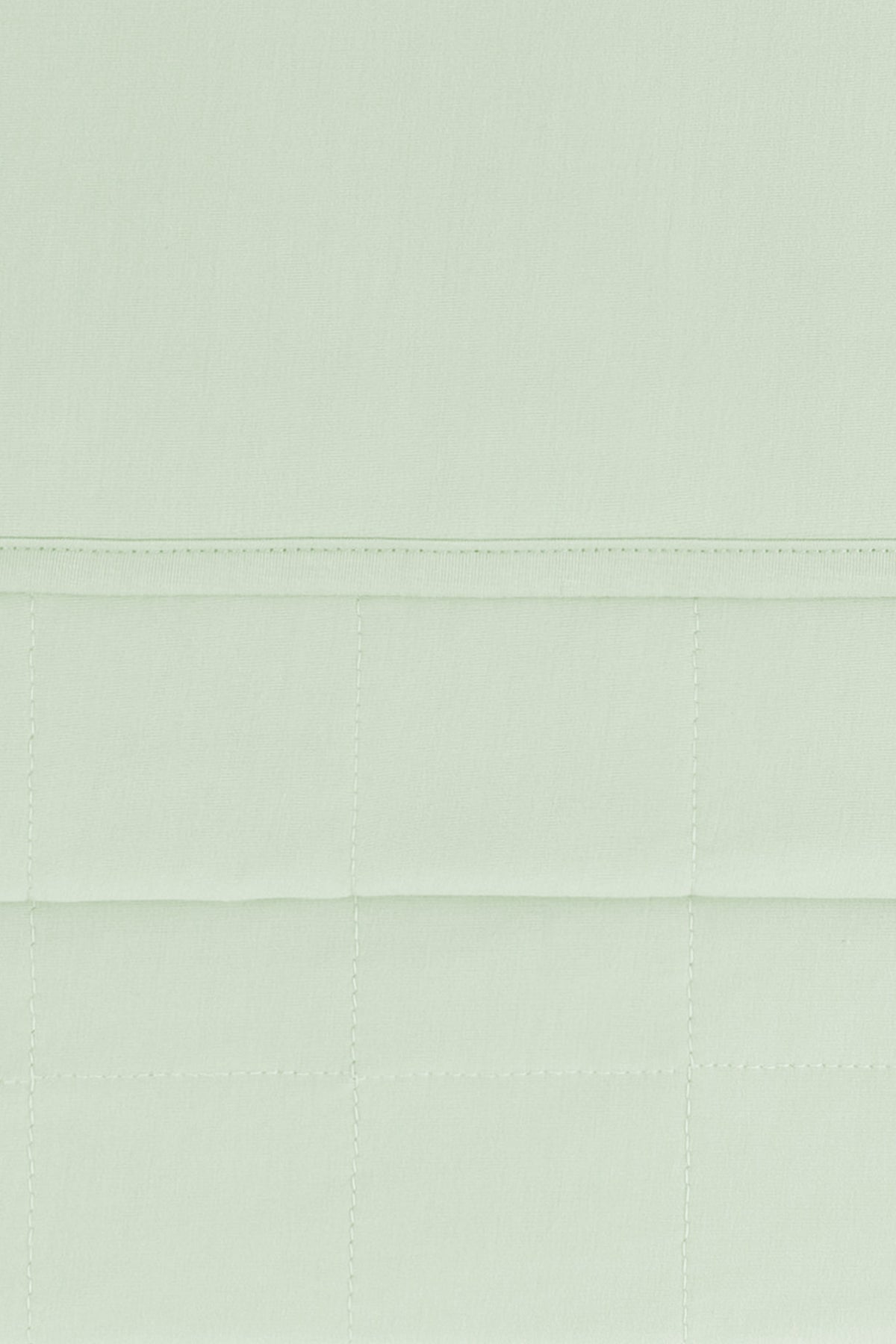 Close up of the quilted bottom and smooth top layer of the Adult Quilted Blanket in Basil 1.0