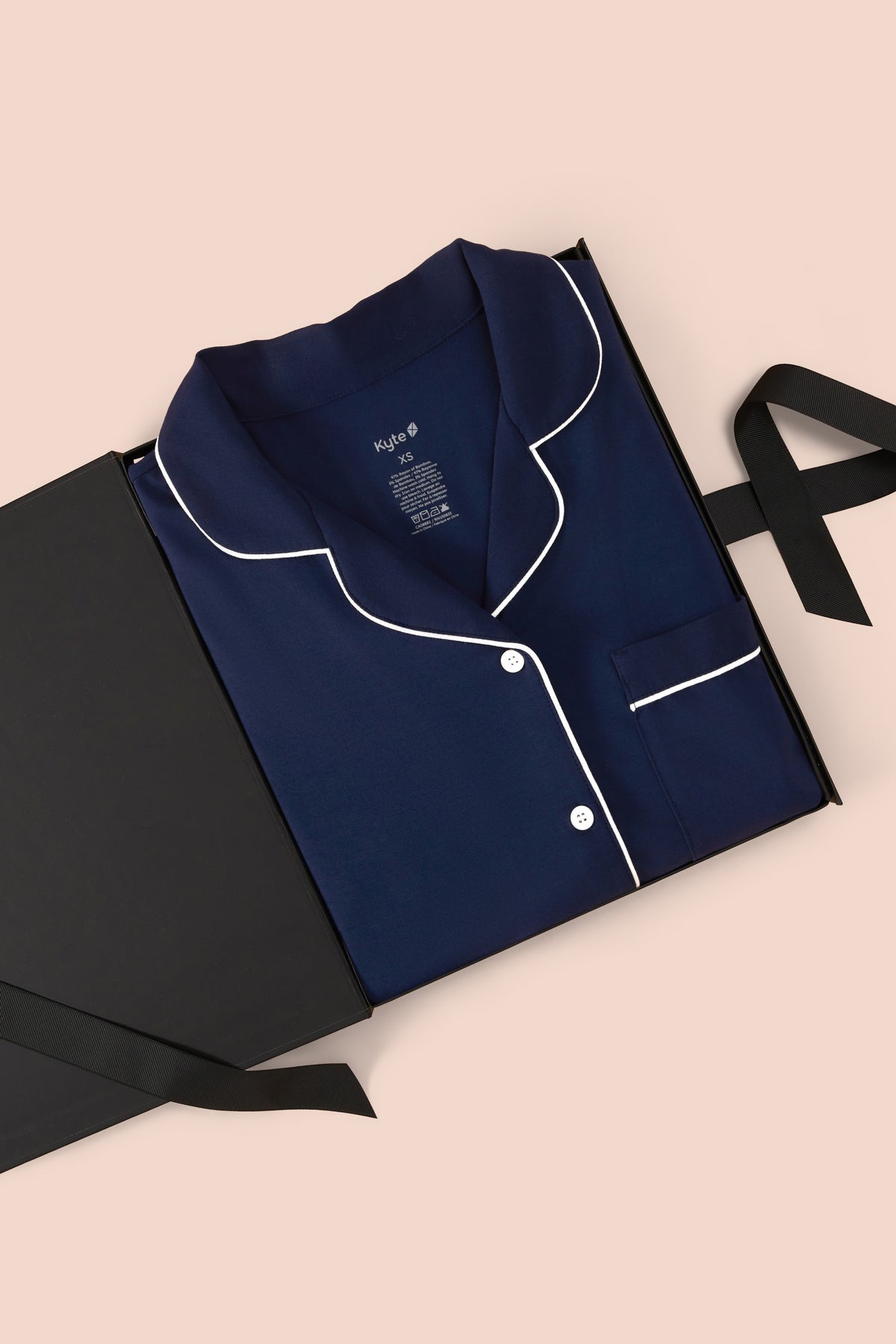 Women’s Short Sleeve Pajama Set in Navy with Cloud Trim packed in a box on a beige background