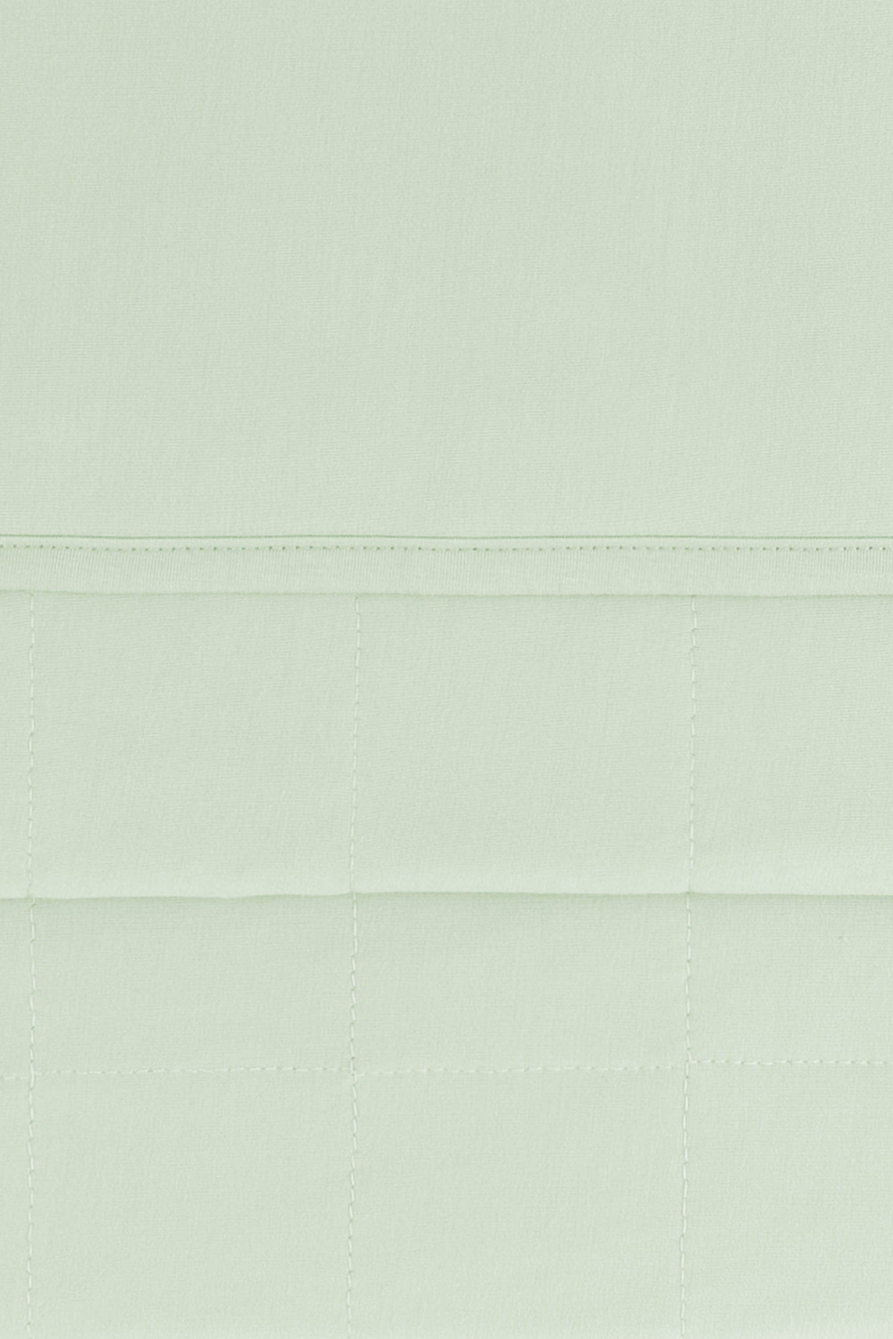 Close up of the Youth Blanket in Basil 1.0 showing the quilted backing and smooth top layer