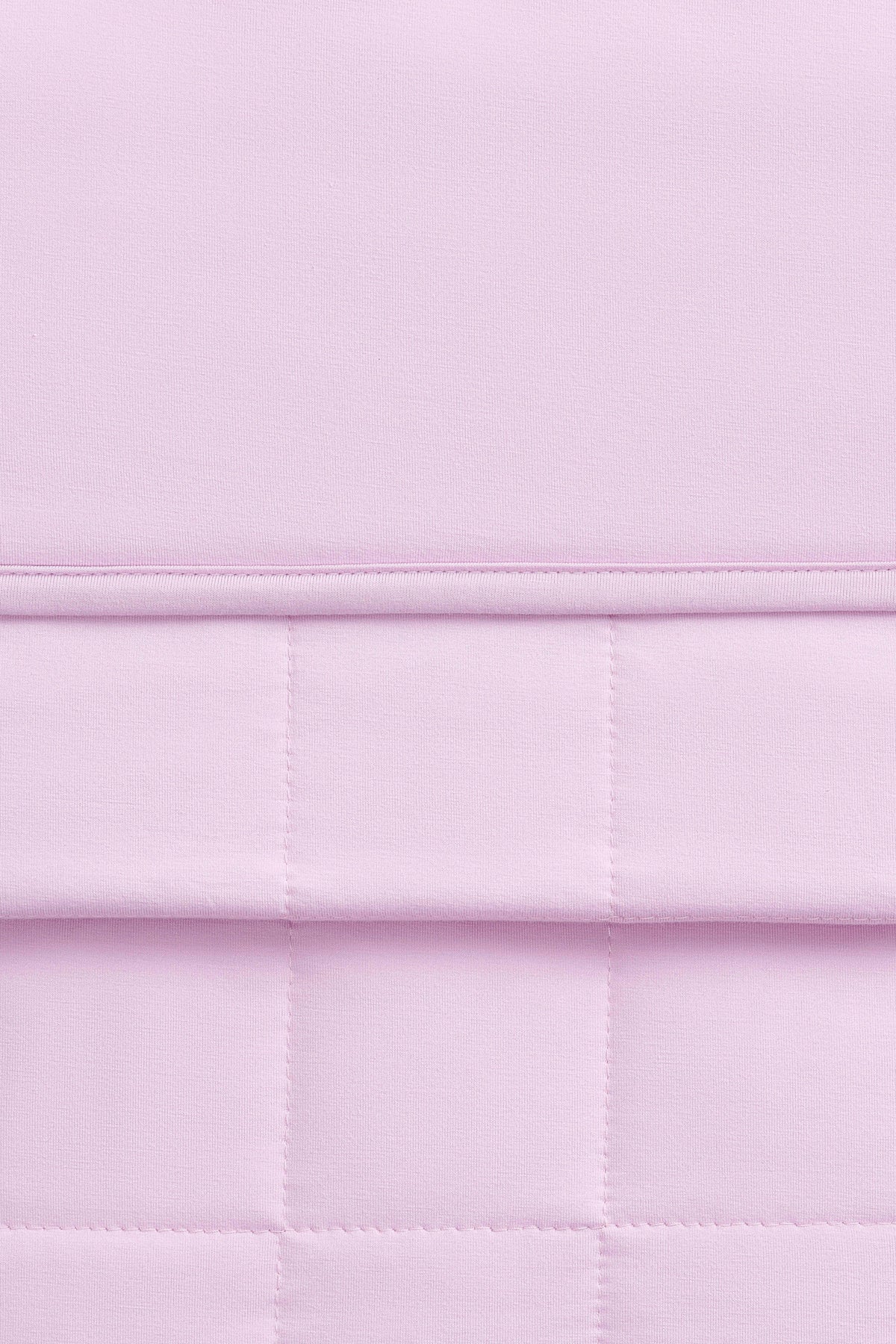 Close up of the Youth Blanket in Thistle 1.0 showing the quilted backing and smooth top layer