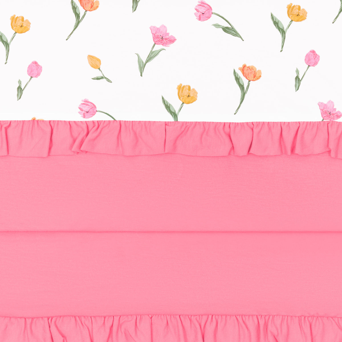 Close up of the Ruffle Toddler Blanket in Tulip 0.5 showing the pink packing, ruffled edges and floral print top layer