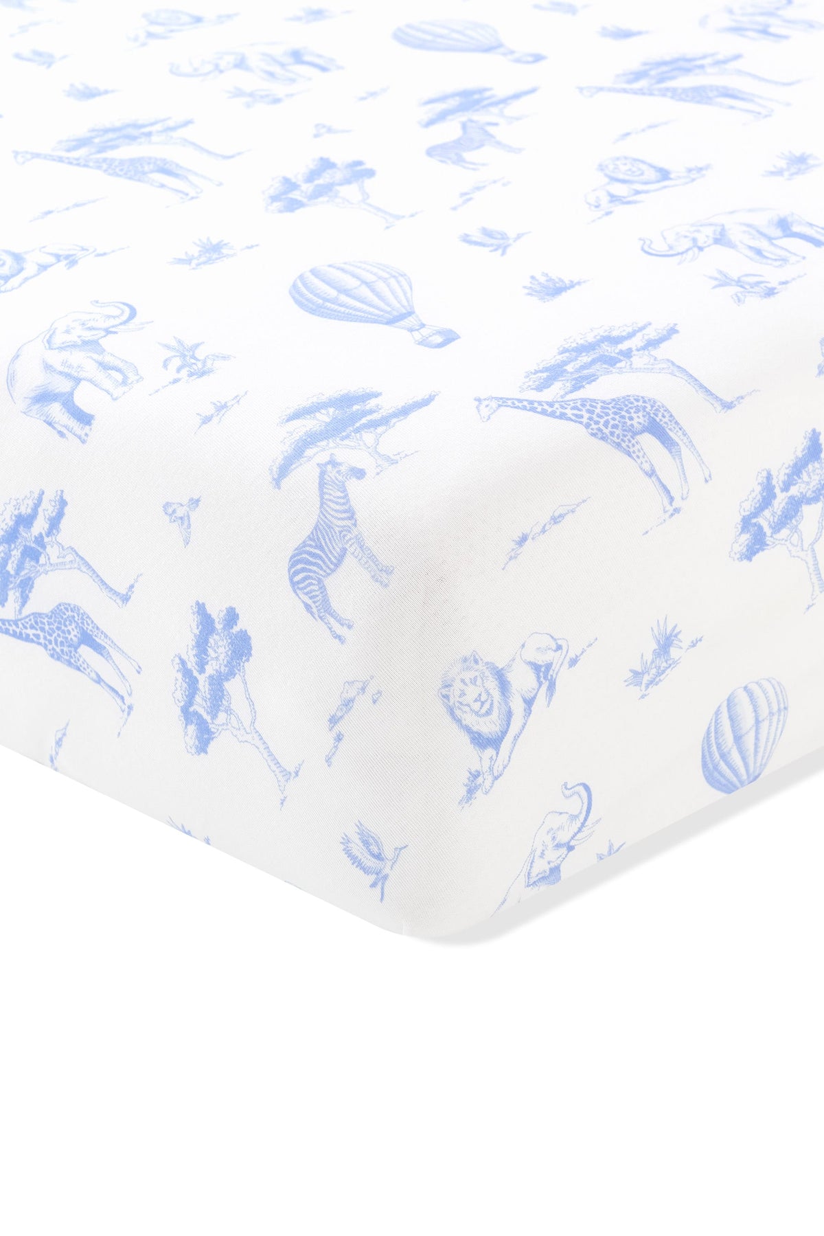 Close up of the corner of the Crib Sheet in Toile Safari shown on a crib mattress