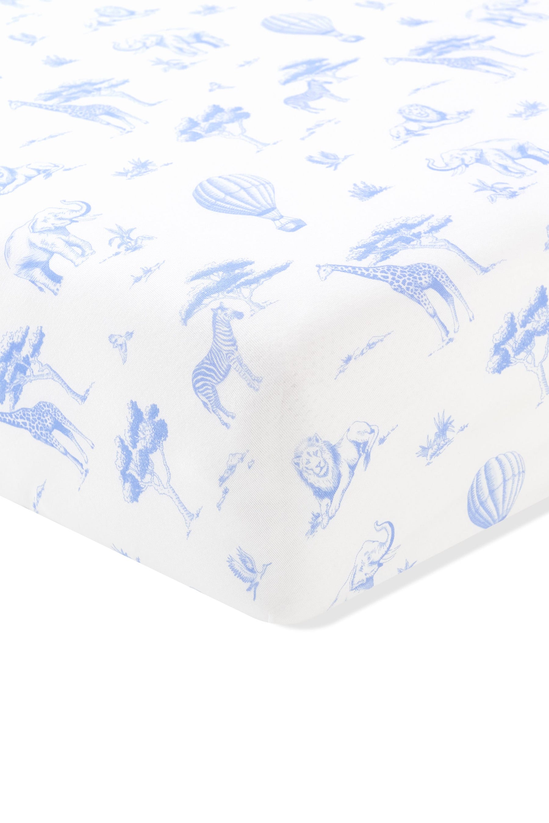Close up of the corner of the Crib Sheet in Toile Safari shown on a crib mattress