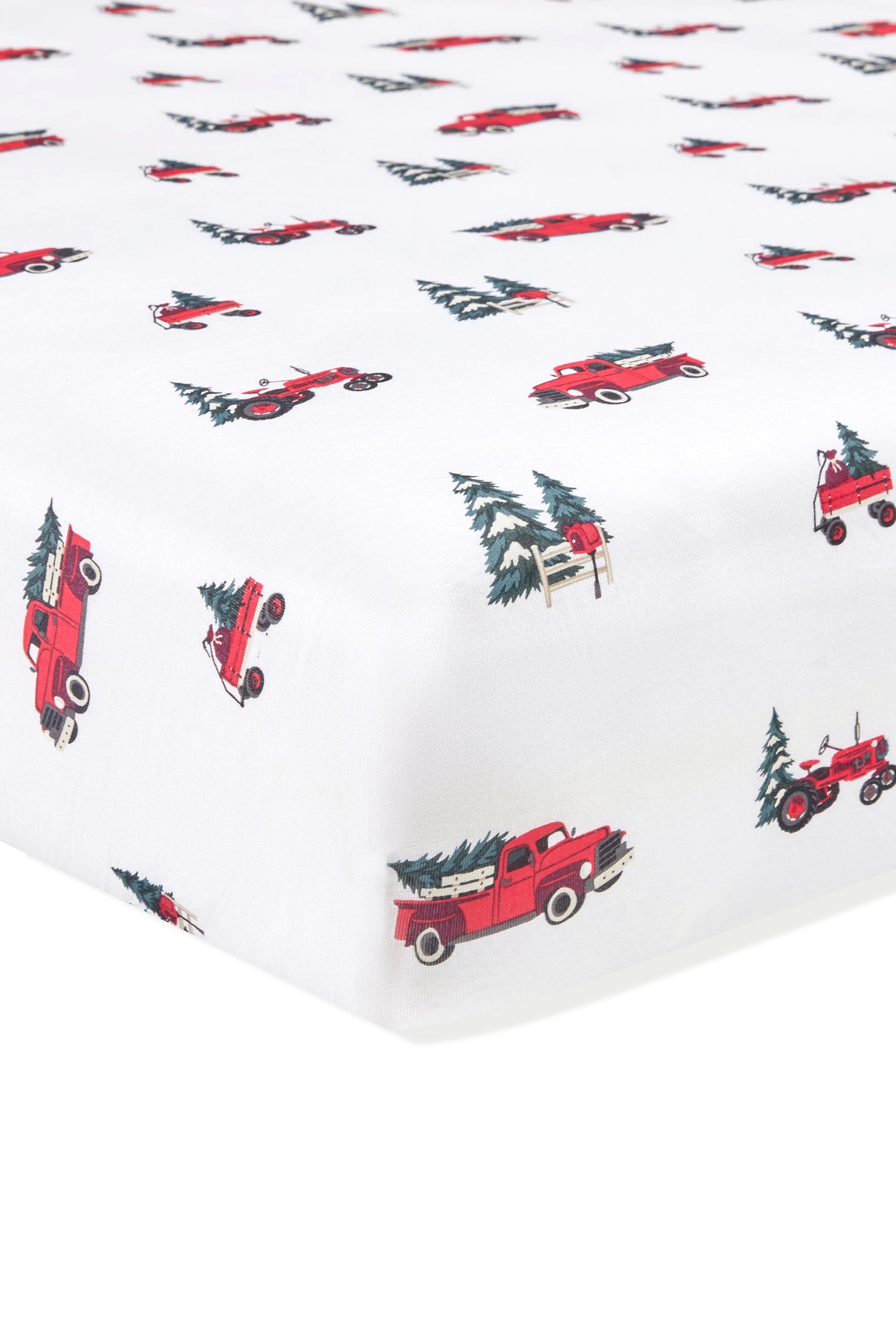 White fitted sheet with a repeating pattern of red vintage pickup trucks carrying Christmas trees and small evergreen trees.