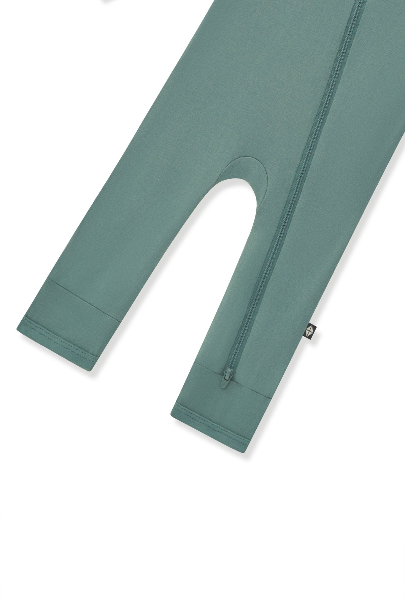 Bottom zipper shown on the leg of the Zippered Romper in Pine on a white background