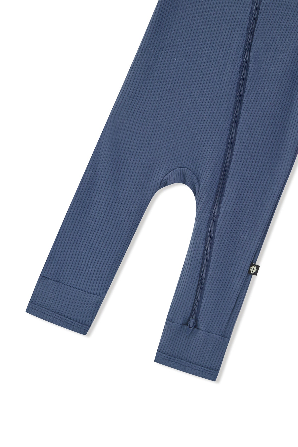 Zipper shown on the leg of the Ribbed Zipper Romper in Oxford on a white background