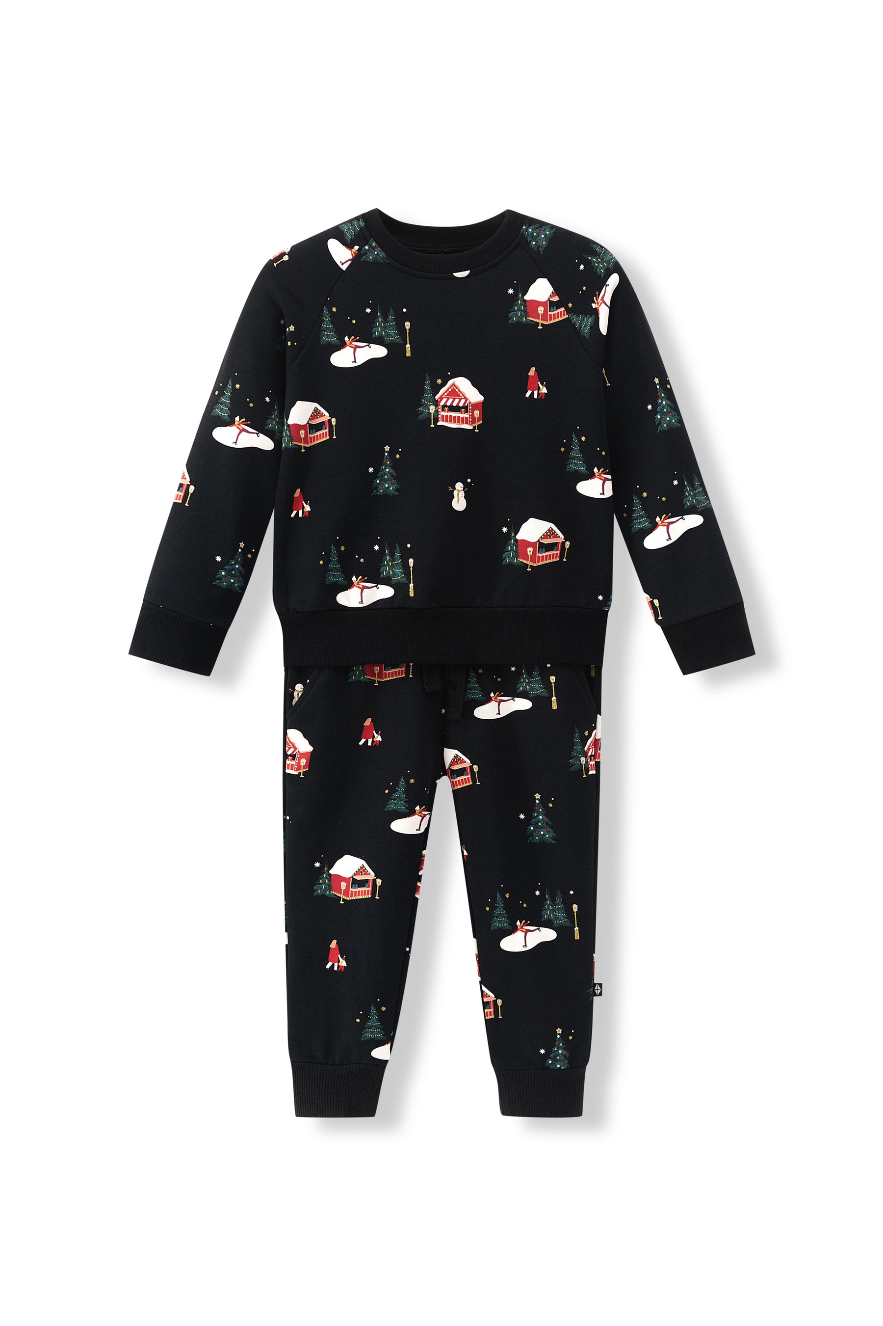 A two-piece kids' set featuring a long-sleeve top and matching pants in black, both printed with a winter holiday scene pattern of snow-covered cabins, evergreen trees, and snowflakes.