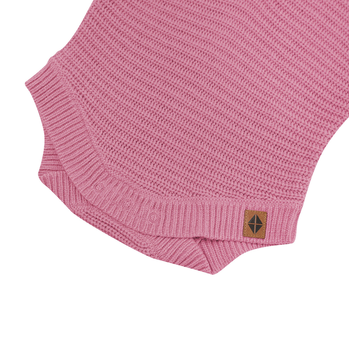 Snap closures shown on the Chunky Knit Romper in Apple Blossom with the Kyte Baby vegan leather tag visible