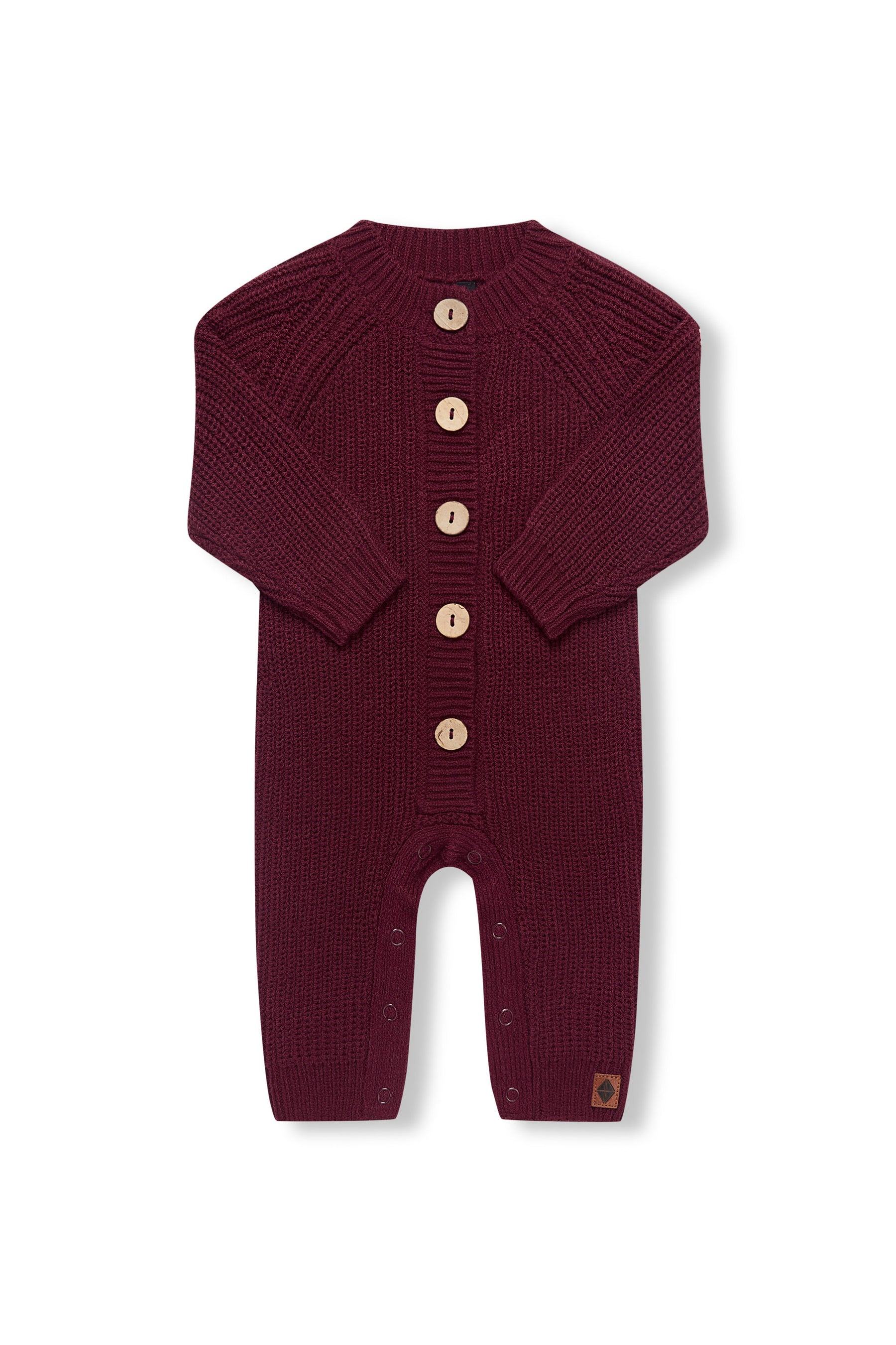Chunky Knit Jumpsuit in burgundy with folded sleeves on a white background