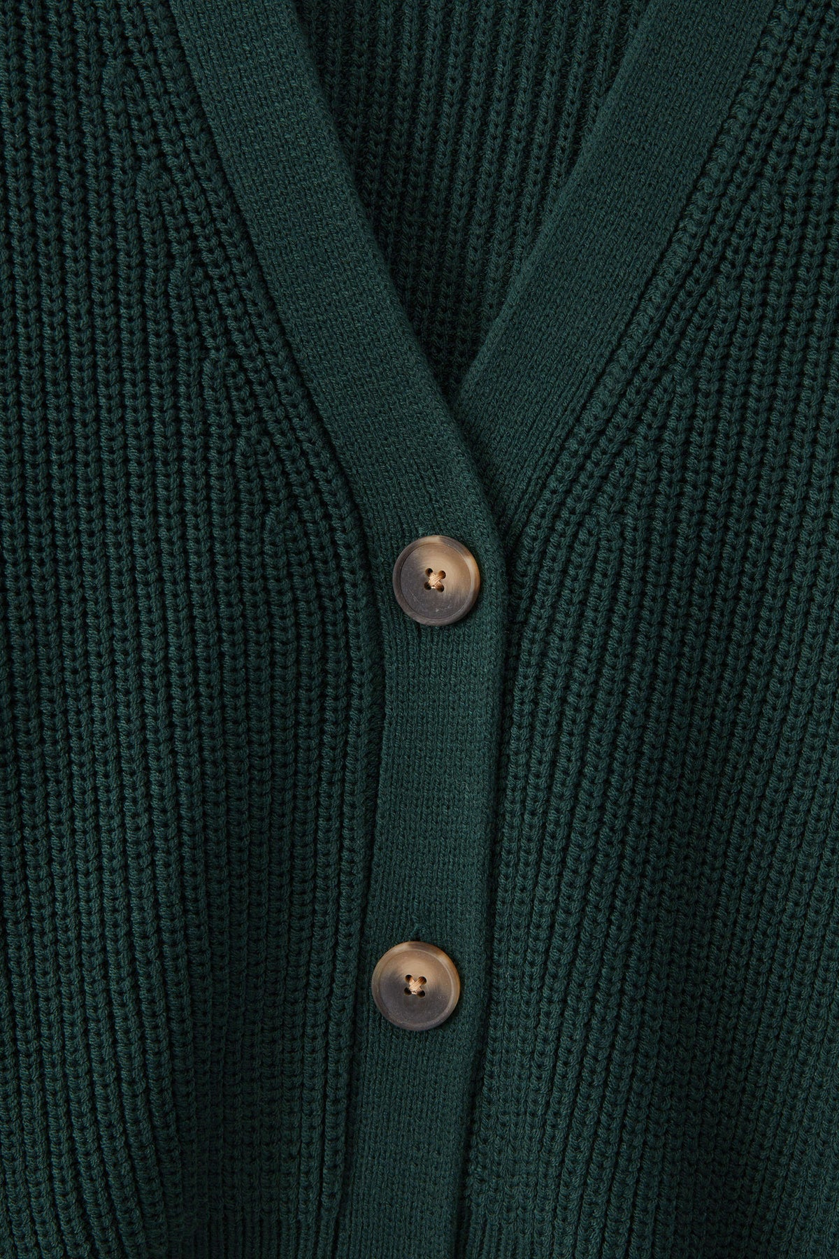 Close-up of a dark green ribbed knit cardigan with a V-neck and two metallic buttons.