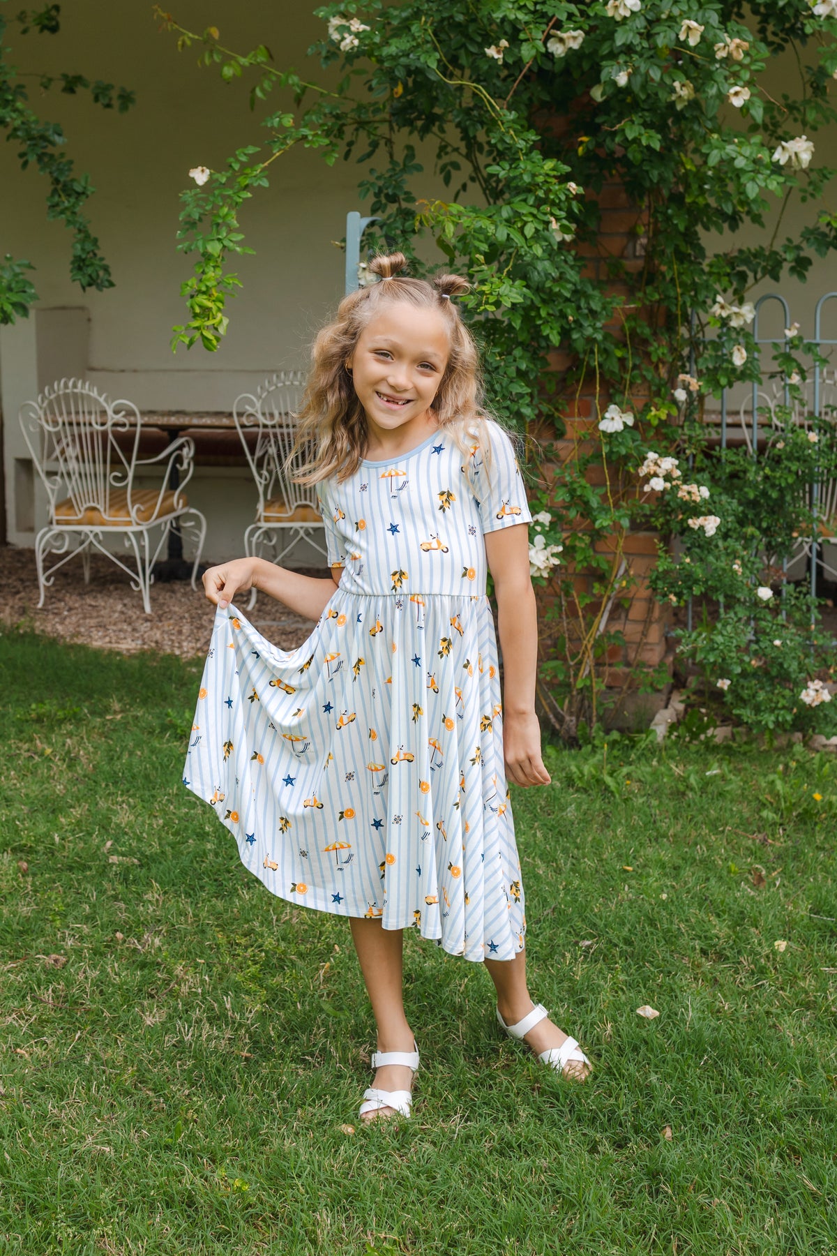 Young girl in a short sleeve dress standing in a garden
