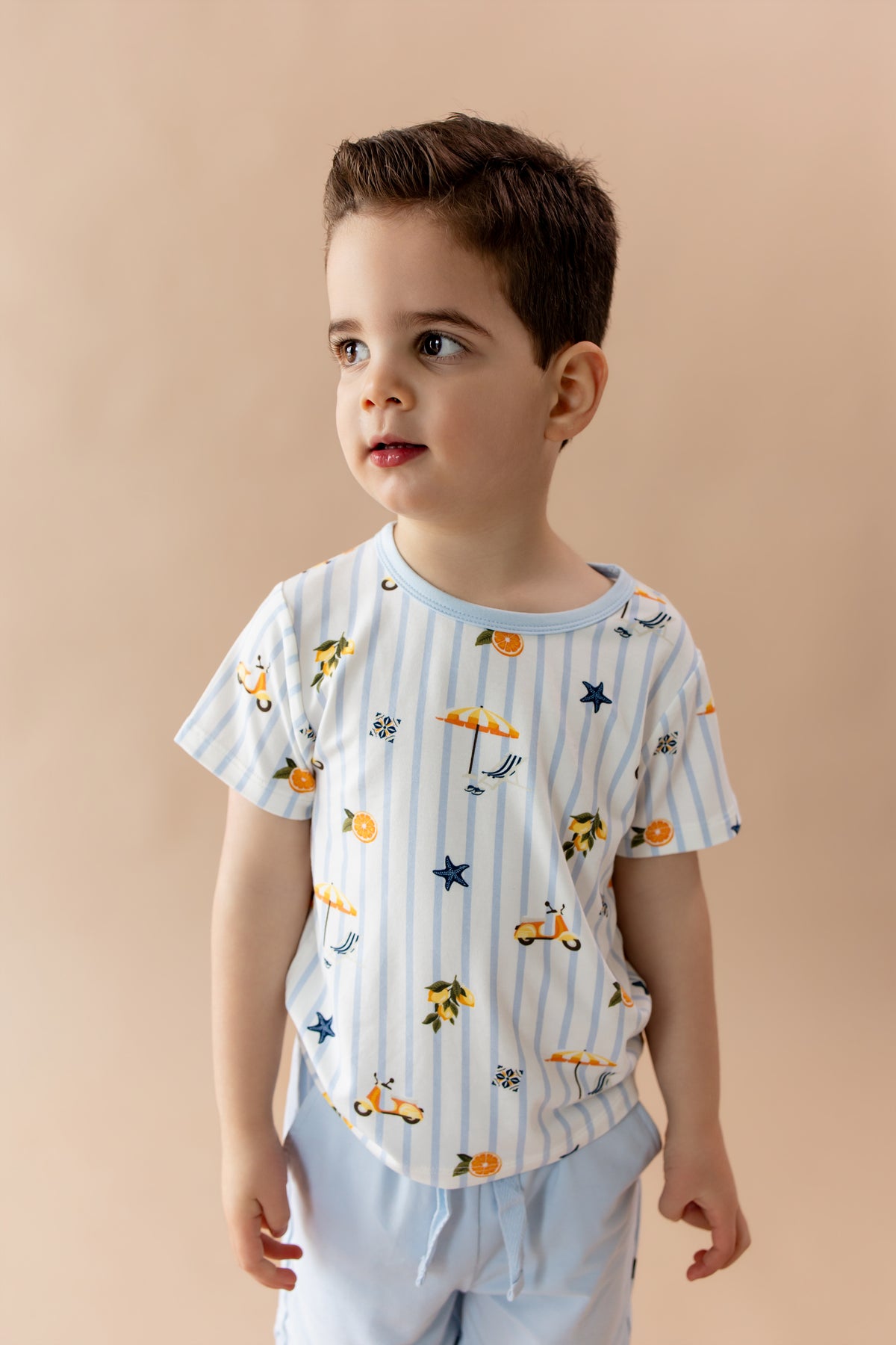 Young boy wearing the Toddler Basic Tee in Amalfi Coast with light blue shorts
