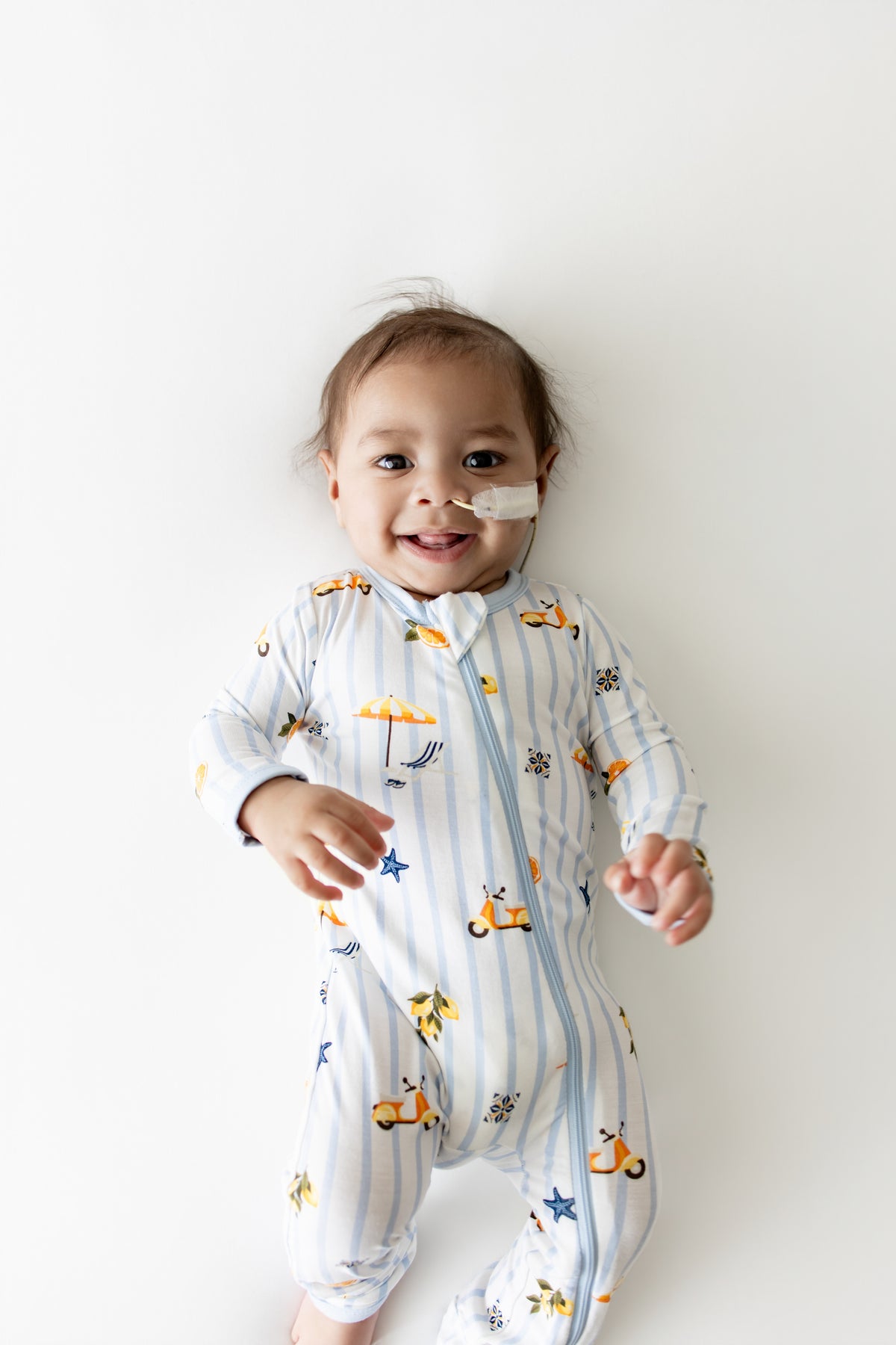 Close up of smiling infant wearing the Zippered Romper in Amalfi Coast