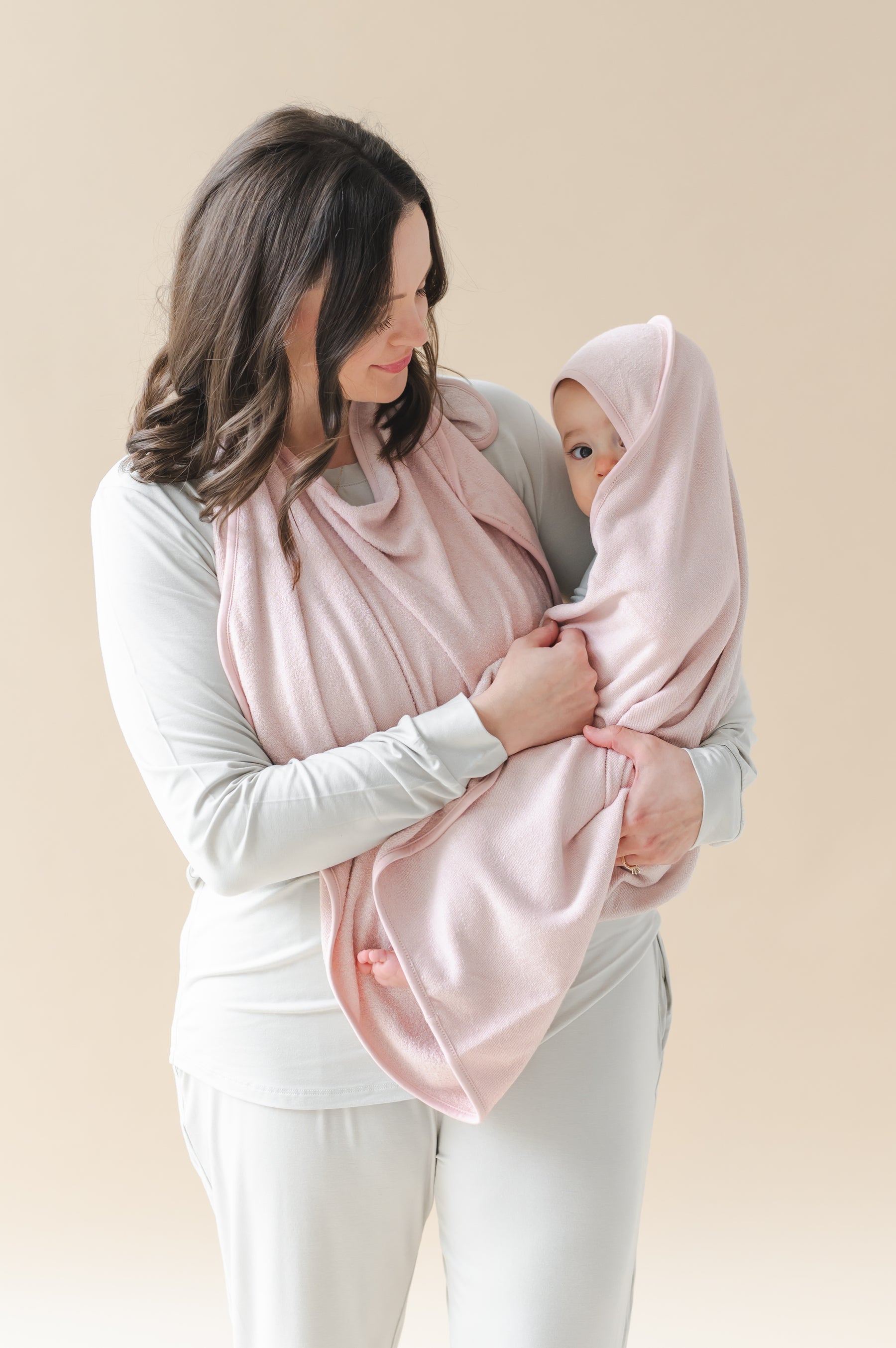 Mother holding her infant wrapped in the Terry Apron Towel in Blush