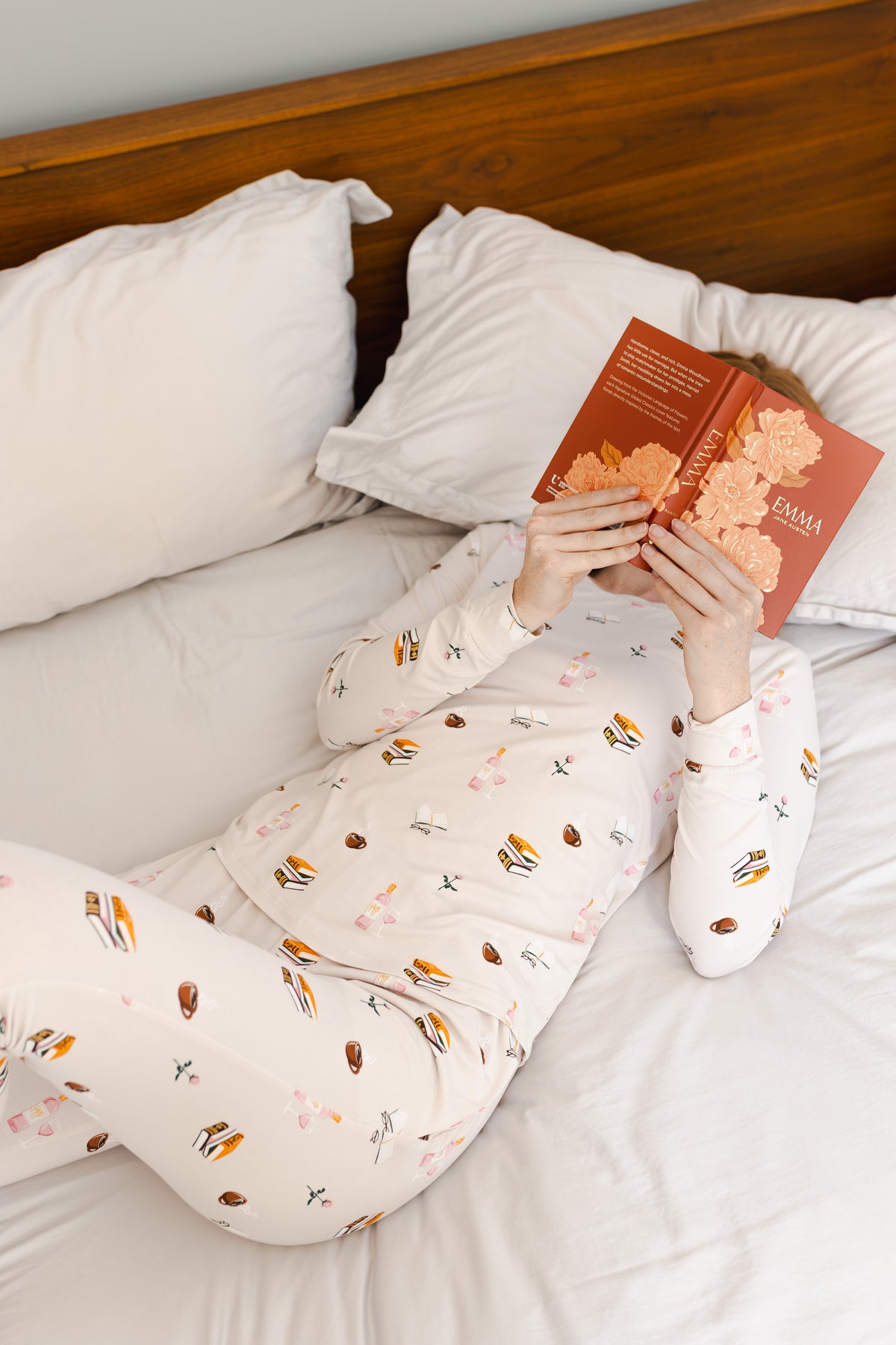 Modal lying on bed wearing Women's Jogger Pajama Set in Book Club print reading a book