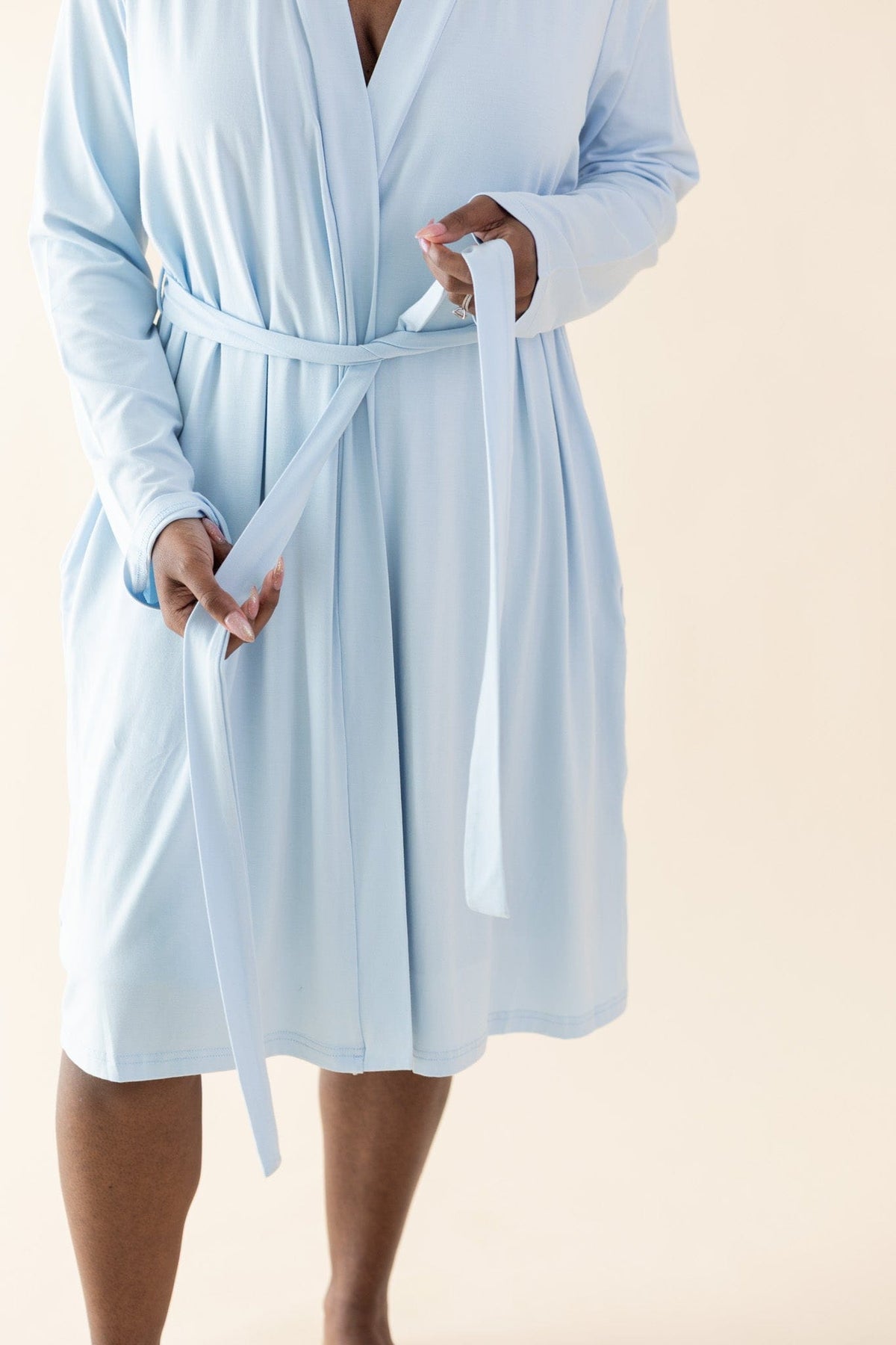 Female tying up the tie waistband of the Women's Lounge Robe in Breeze