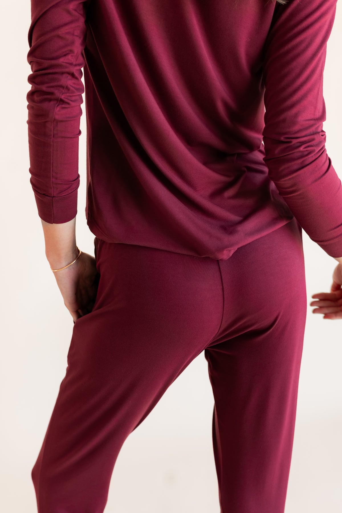 Model showcasing backside of Women's Jogger Pajama Set in Burgundy on a beige background