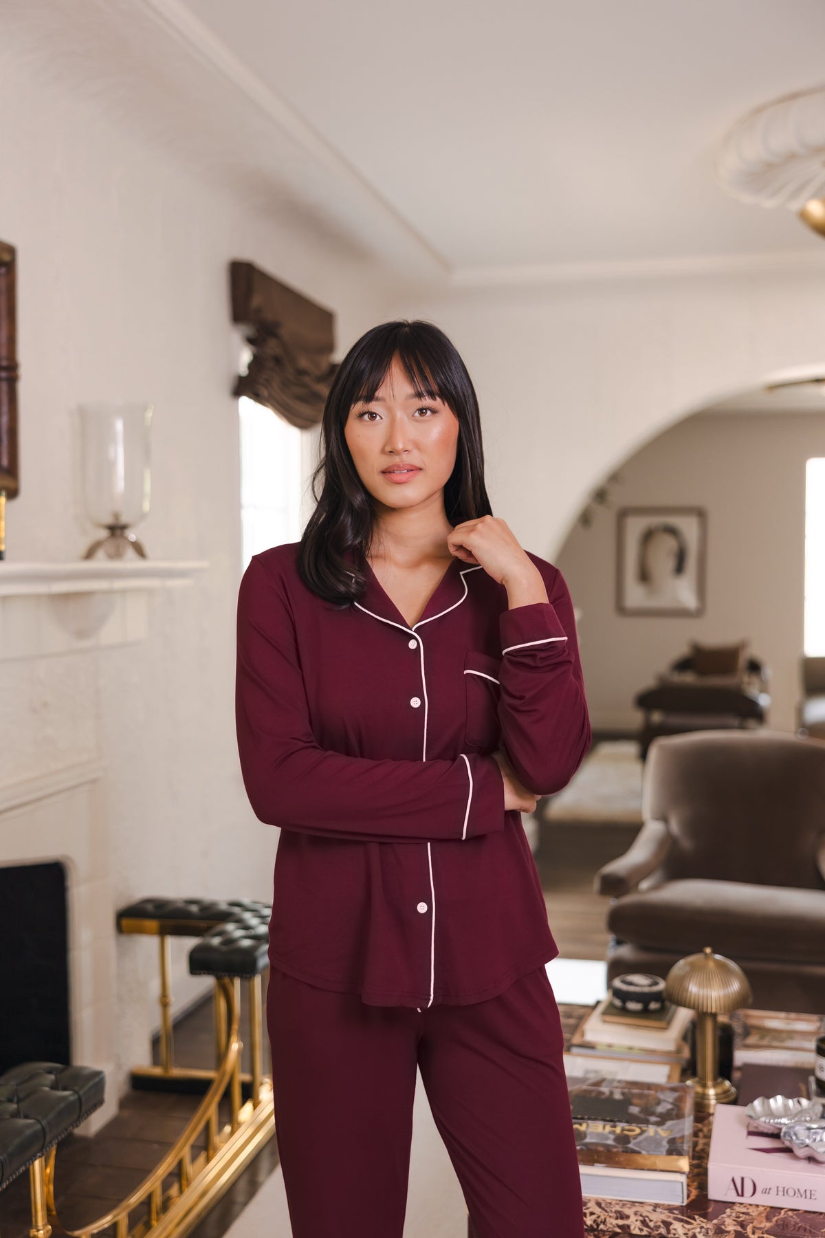 Modal posing in Long-Sleeved Women's Pajama Set in Burgundy with Burgundy Trim standing in a living room