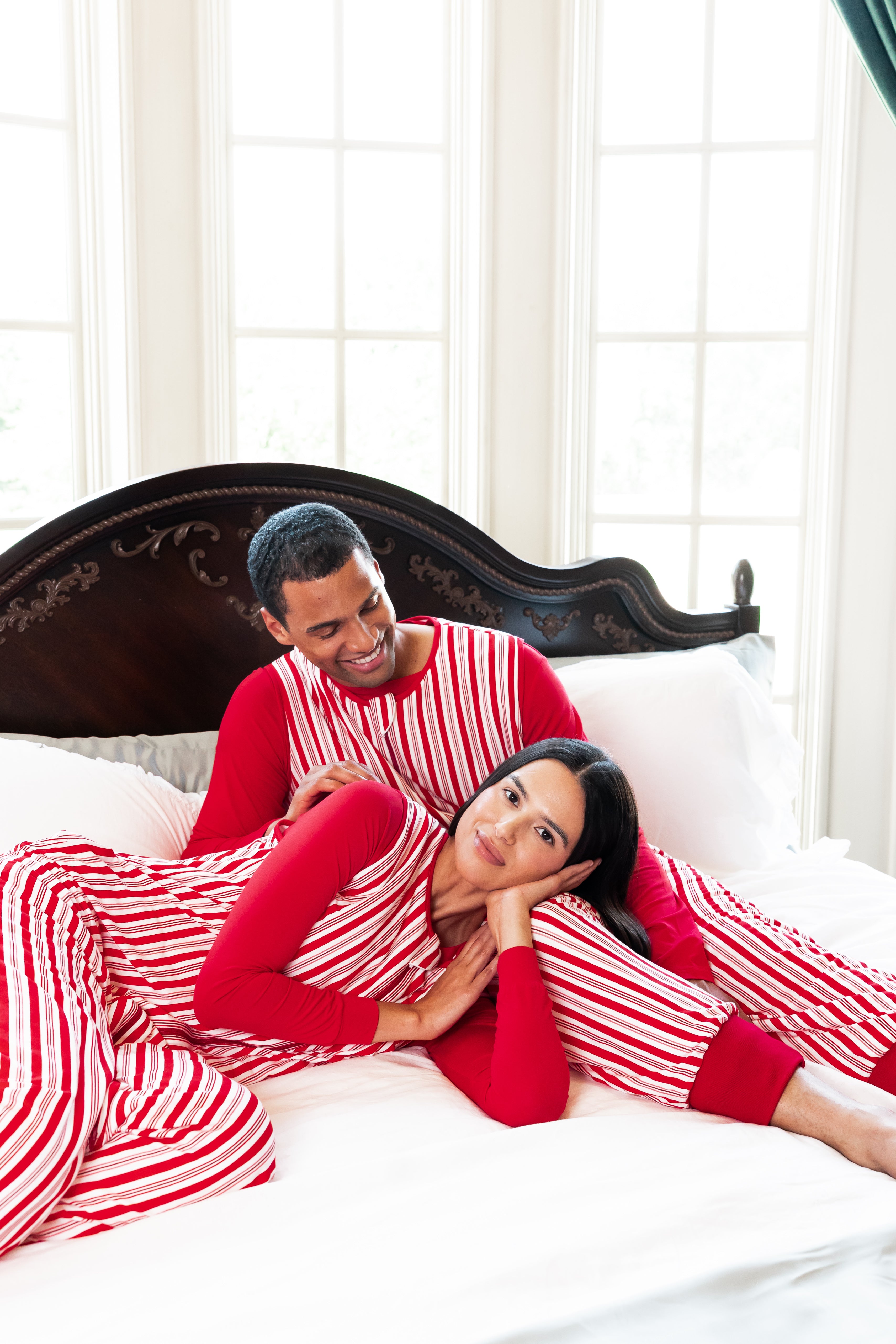 couple wearing matching red striped sleep sacks with red pajamas underneath 