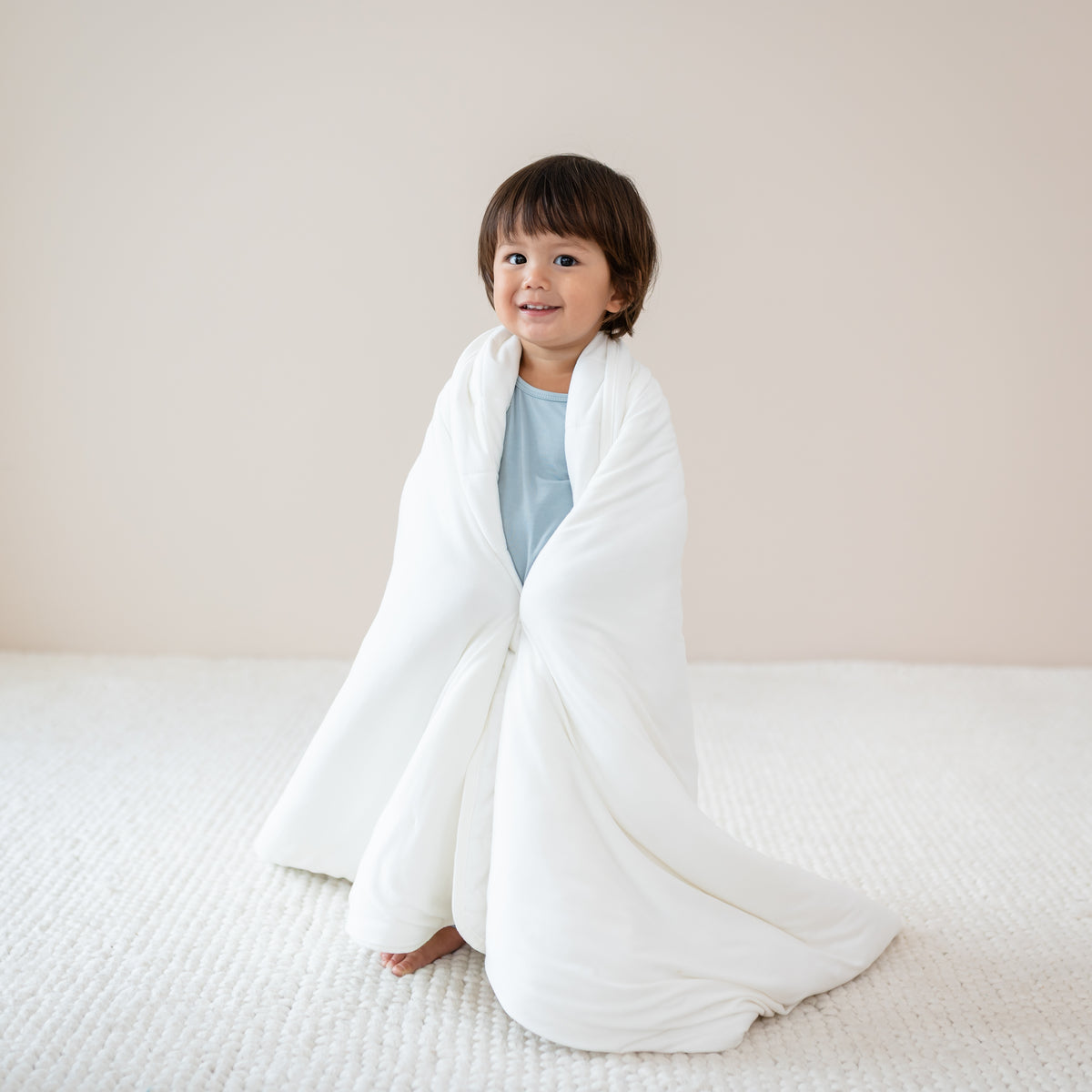 Standing toddler smiling wrapped in Toddler Blanket in Cloud 1.0