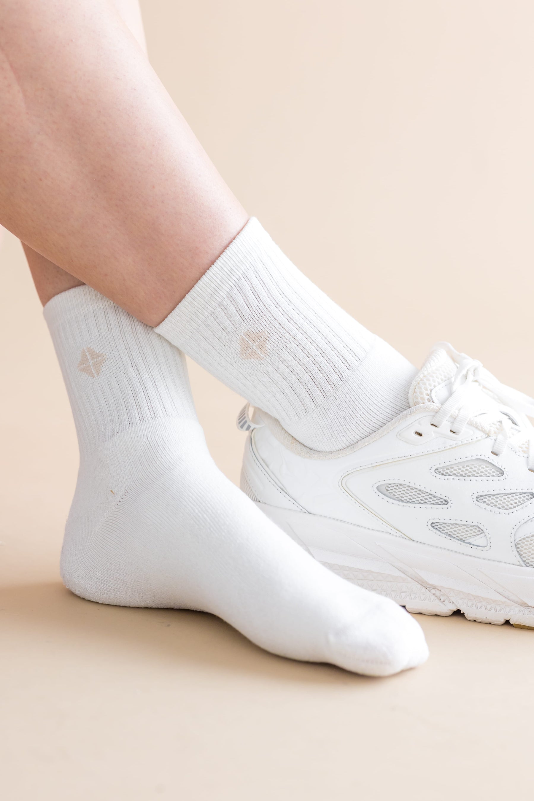 Adult Crew Socks in Cloud shown on a model with a white sneaker on one foot
