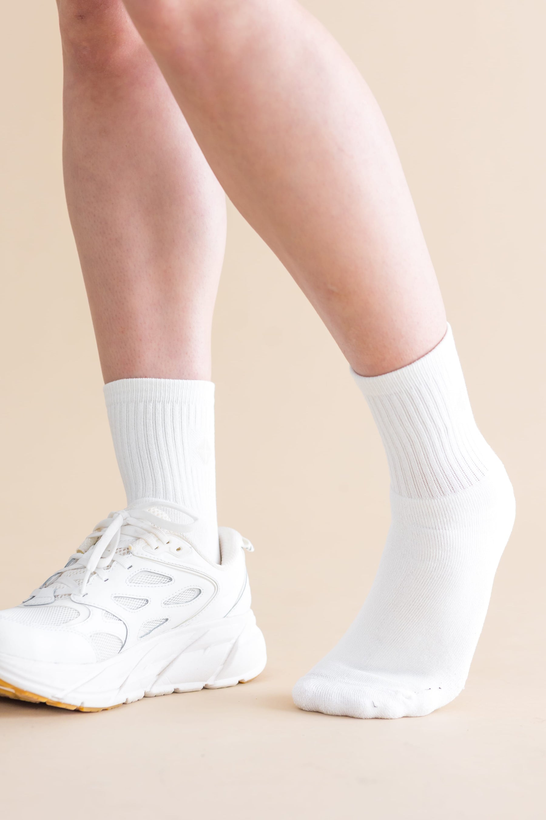 Adult Crew Socks in Cloud shown on models feet with a white sneaker on the right foot